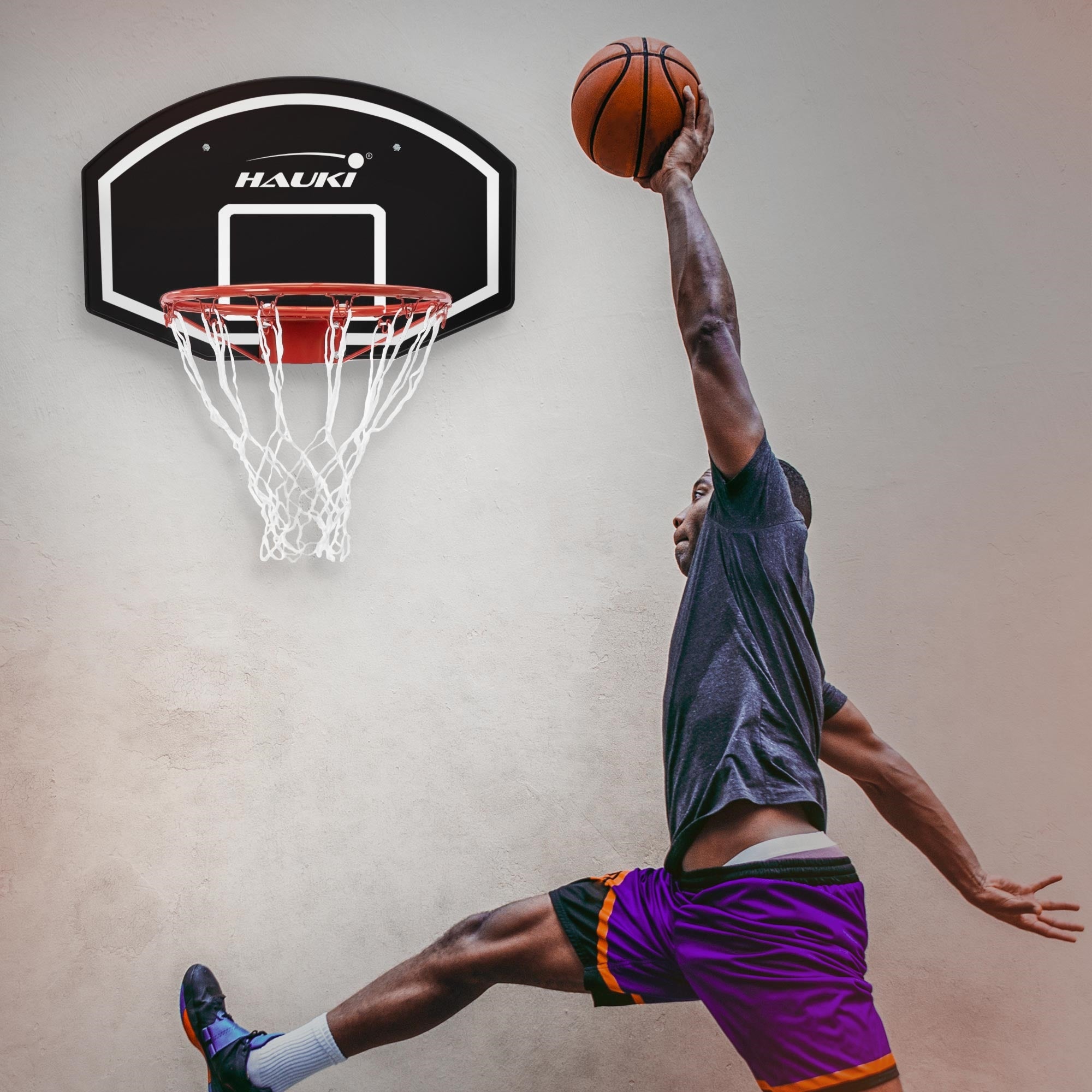 Un joueur saute pour lancer un basketball dans le panier.