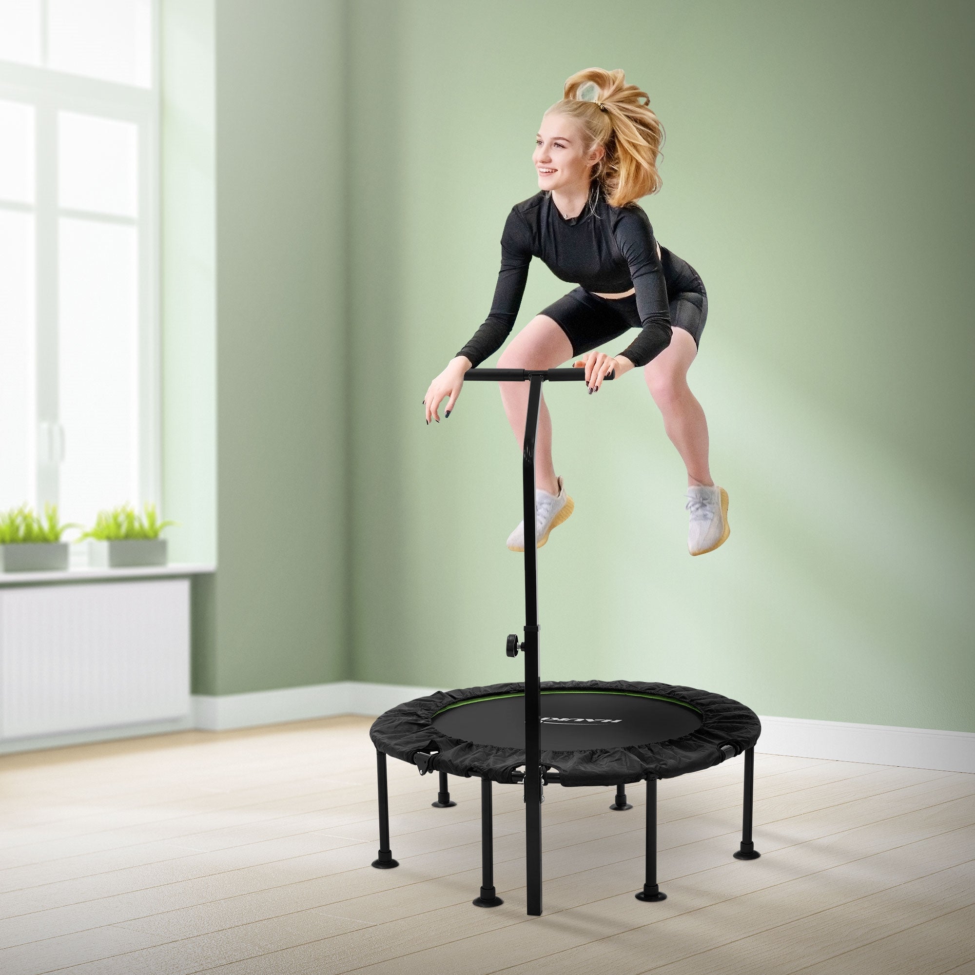 Donna salta su un trampolino con maniglia di sicurezza.