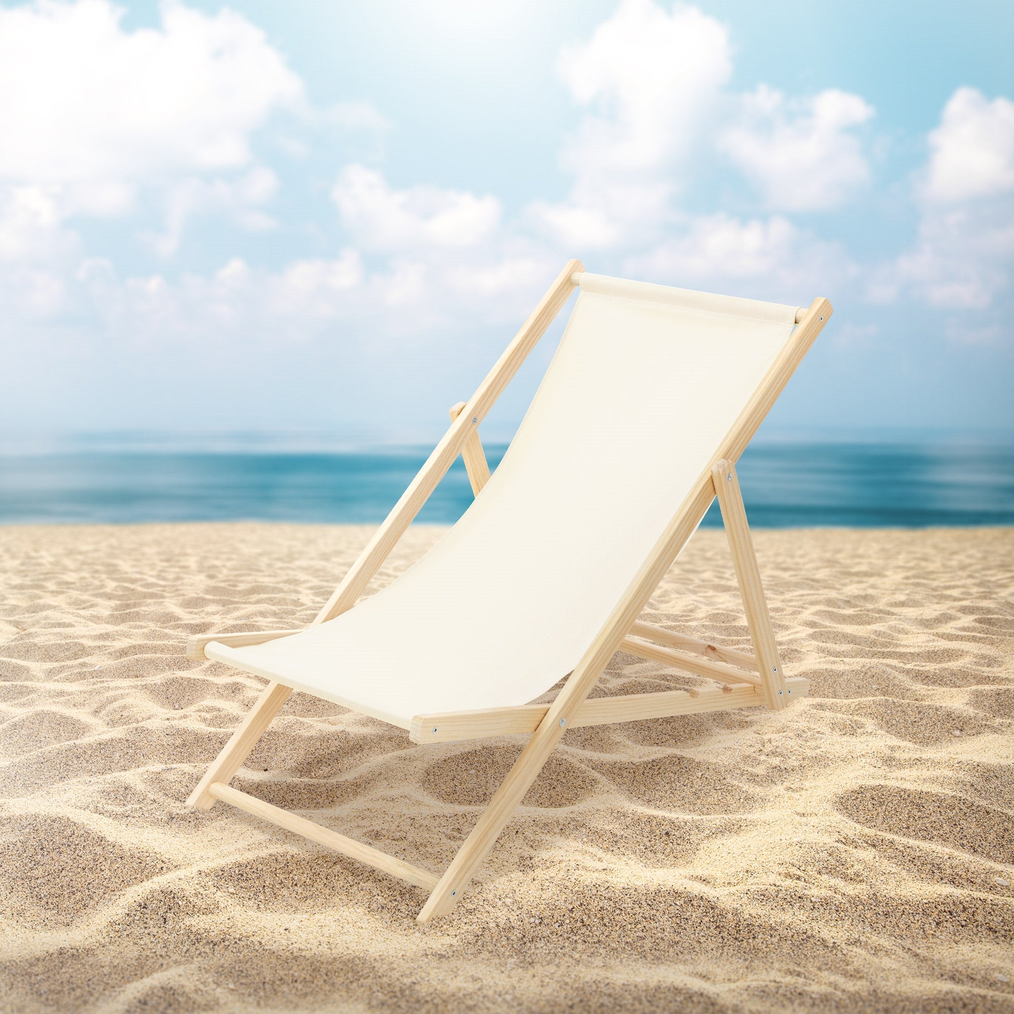 Una sedia a sdraio in legno si trova sulla spiaggia davanti a un cielo blu.