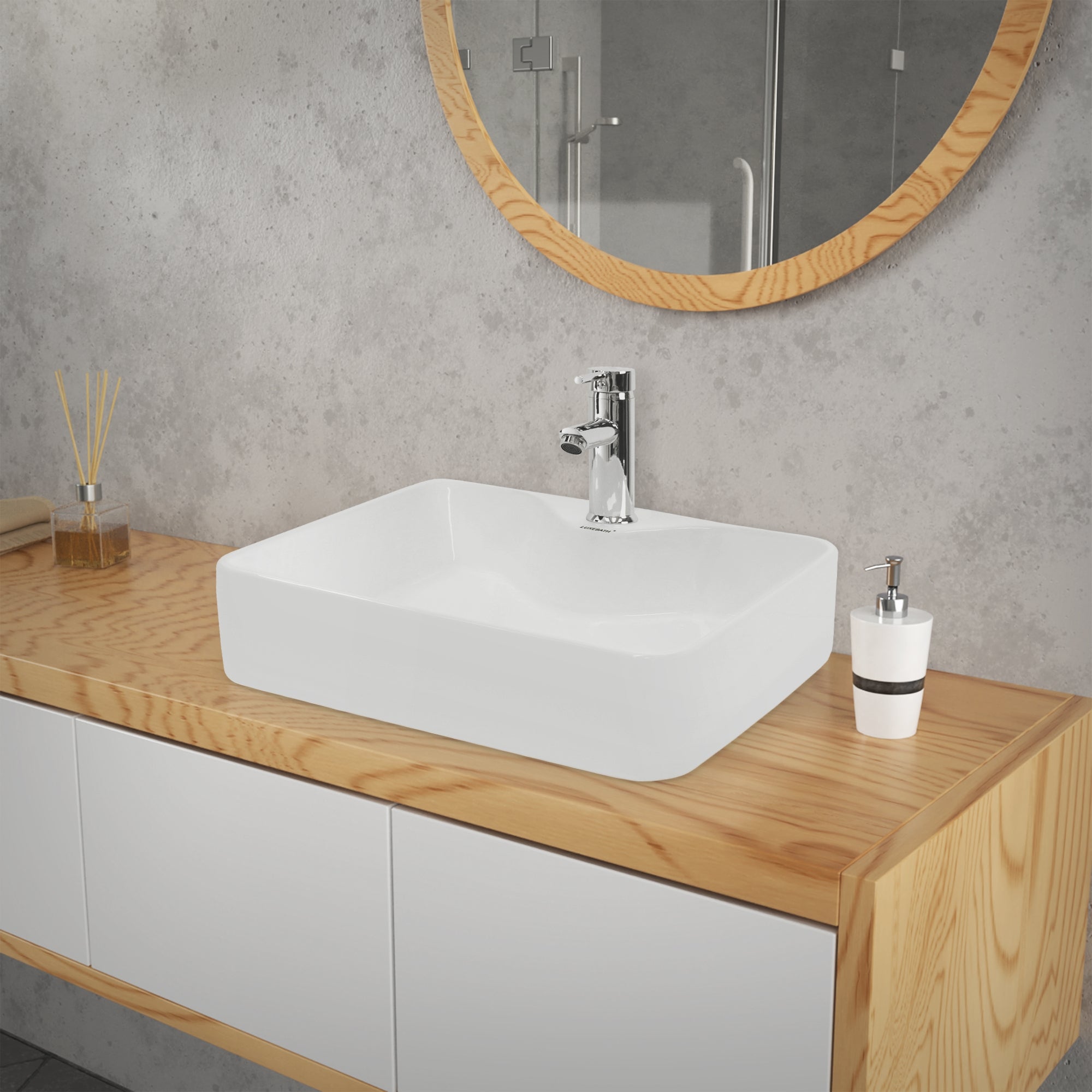 Lavabo blanc sur un meuble en bois devant un miroir dans une salle de bain.