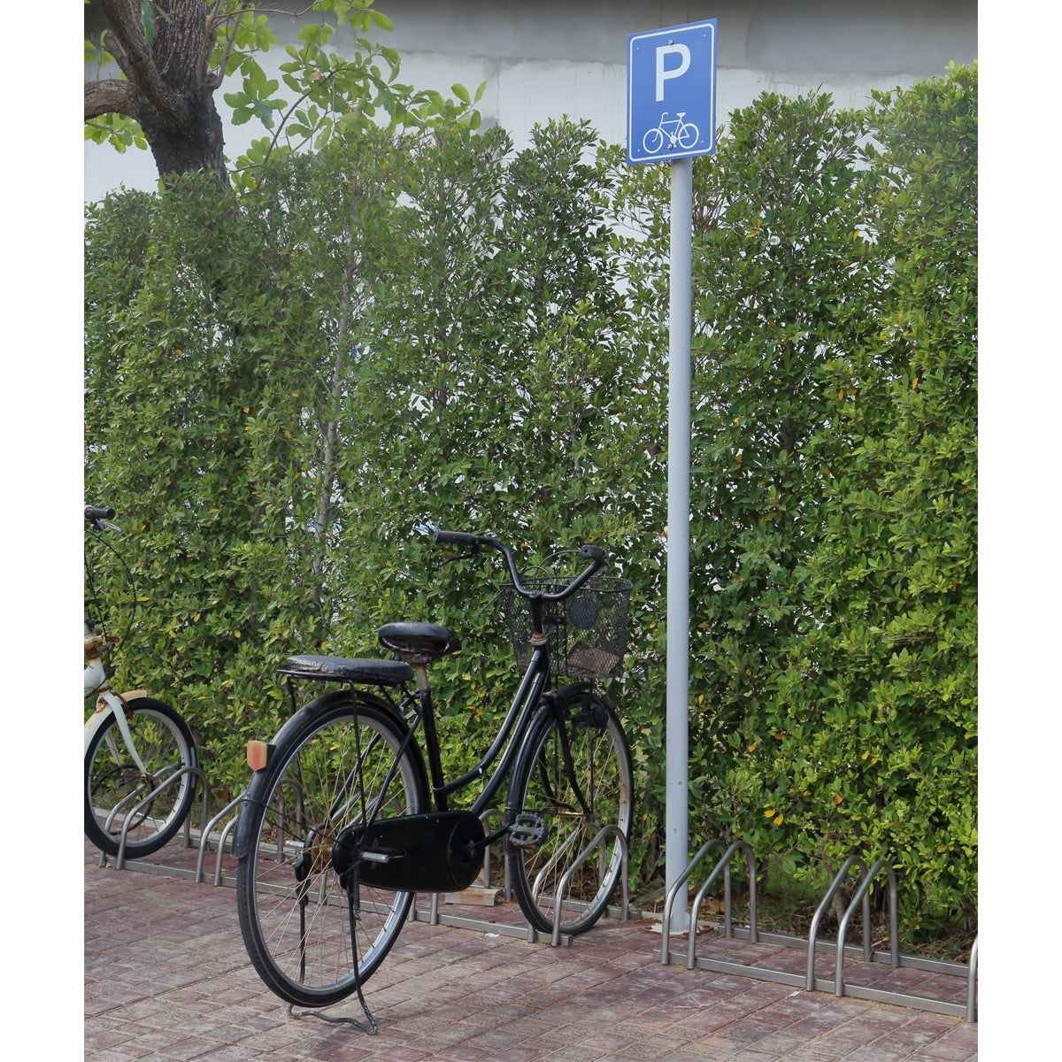 Station de vélo avec un panneau et plusieurs vélos.