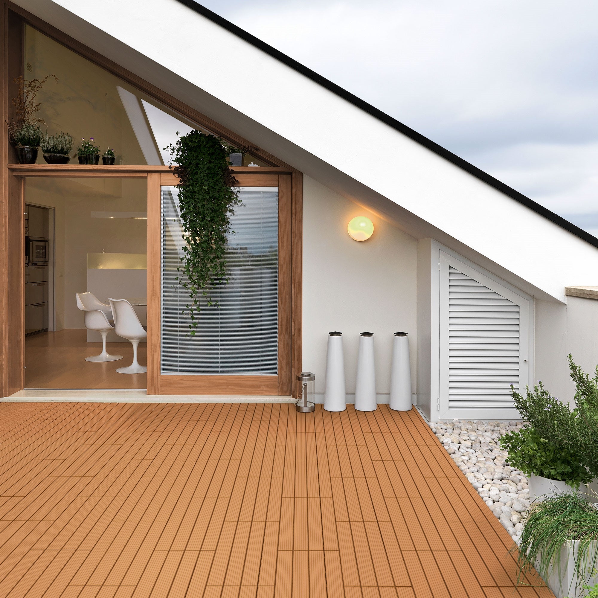 Terrasse mit WPC-Dielen, modernen Möbeln und Pflanzen in einem hellen Raum.