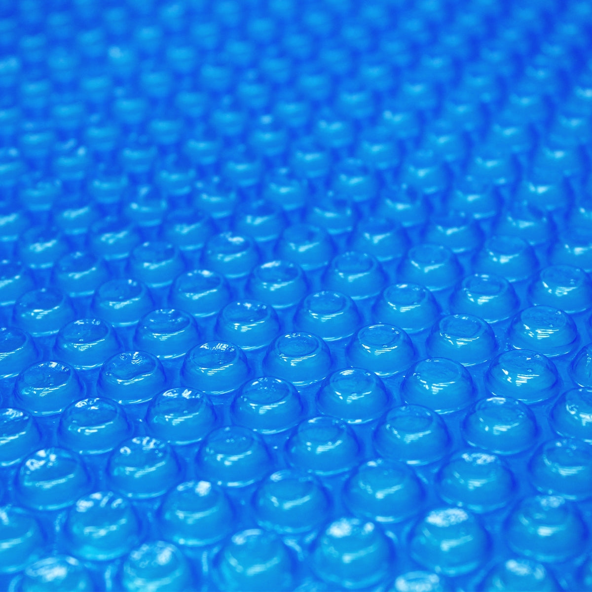 Nahaufnahme einer blauen Poolabdeckung mit vielen kleinen Erhebungen.