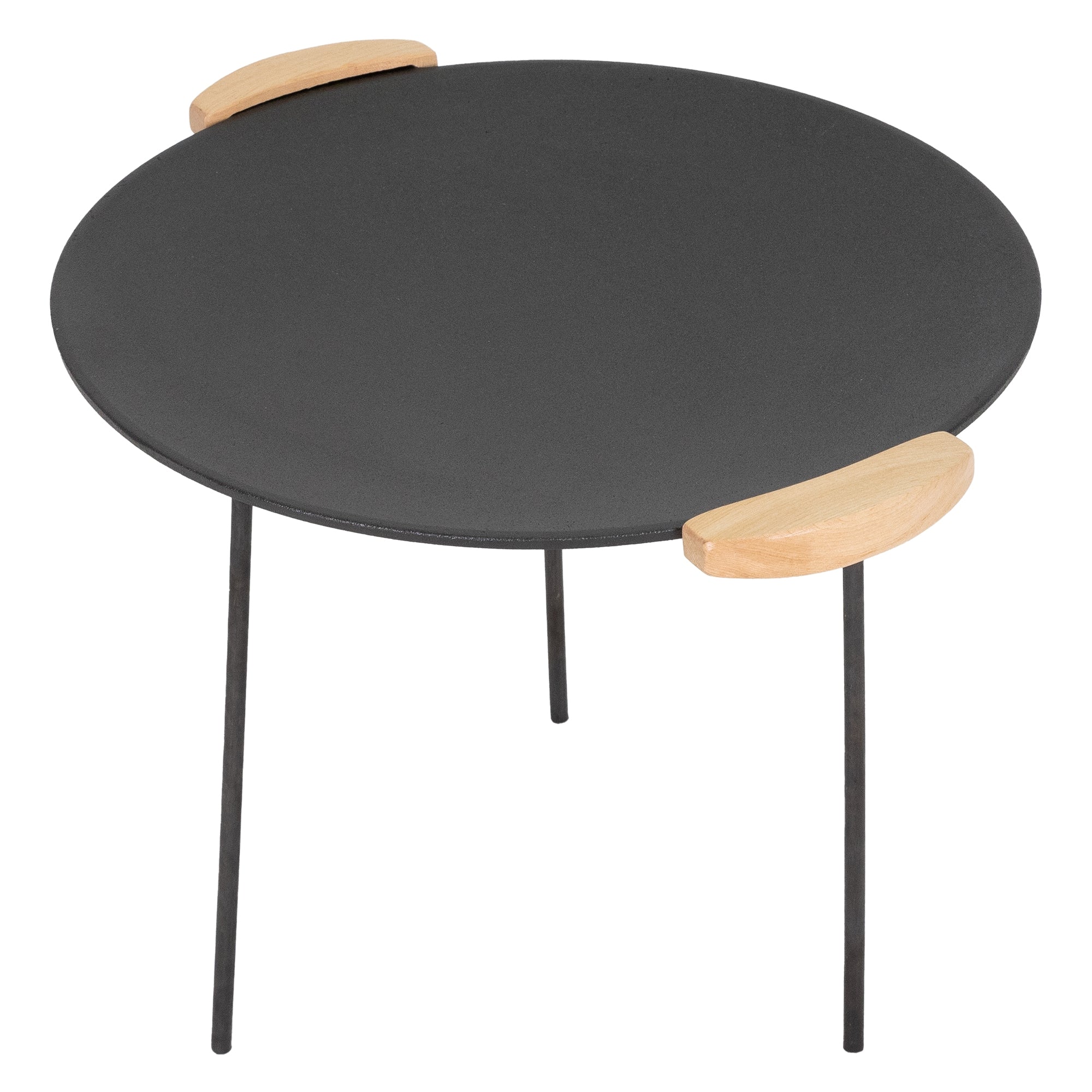 Table ronde avec plateau noir et poignées en bois.