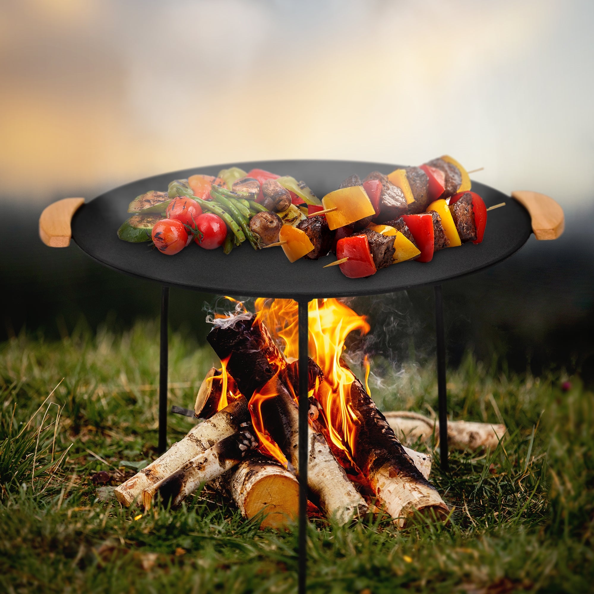 Un barbecue avec des légumes et des brochettes de viande sur un foyer en plein air.