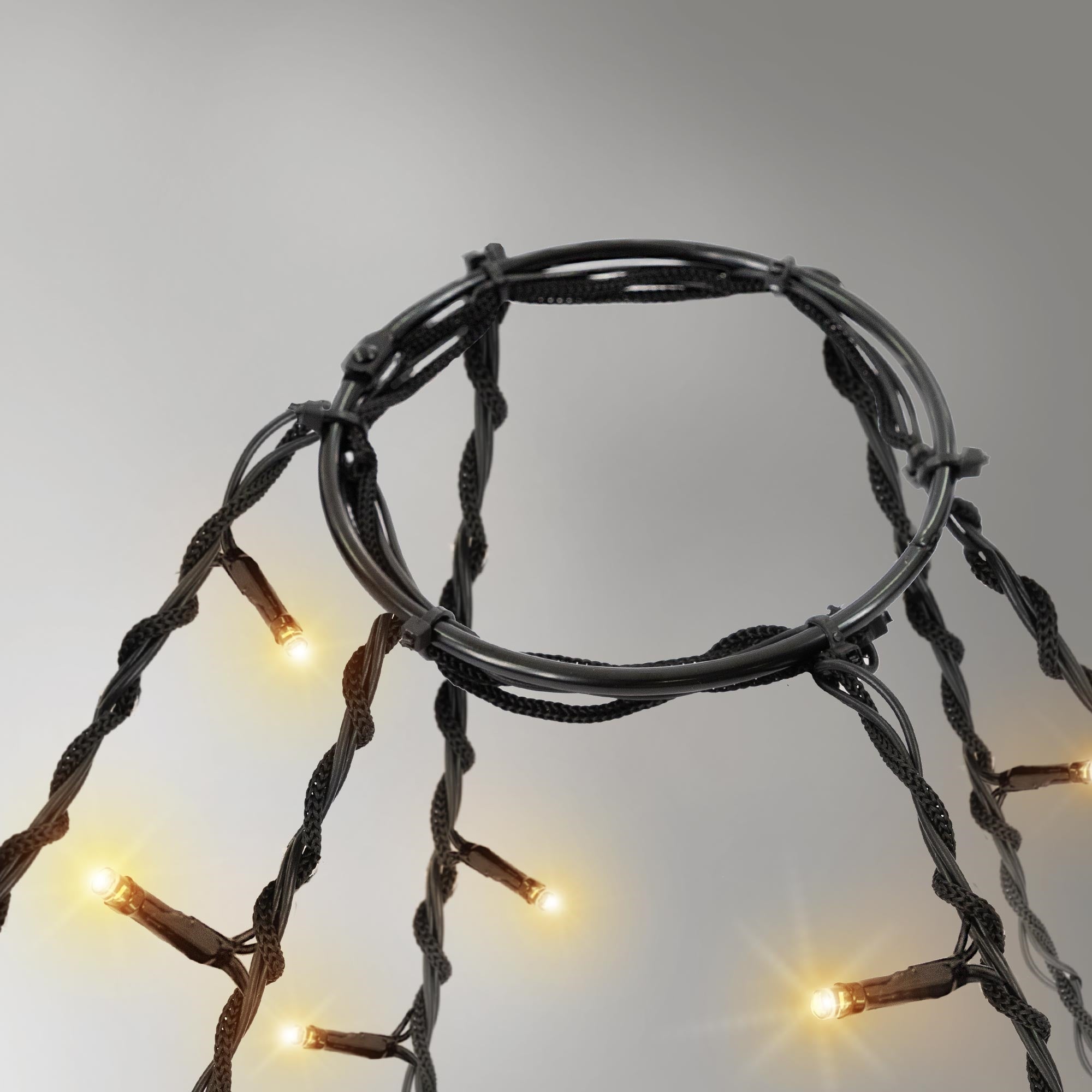 Ein Ring mit Lichtern, die an einem schwarzen Kabel befestigt sind, leuchten sanft.