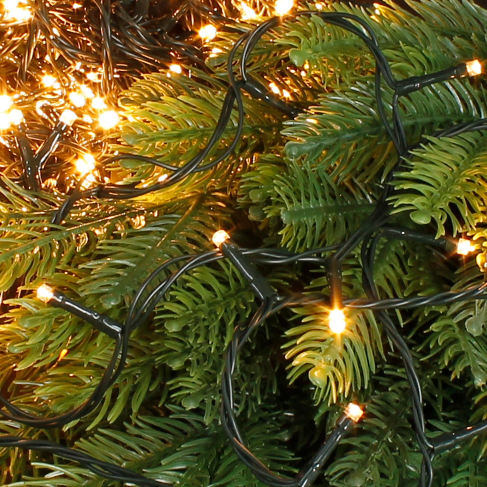 Guirnalda de luces con luces cálidas, rodeada de ramas de abeto.