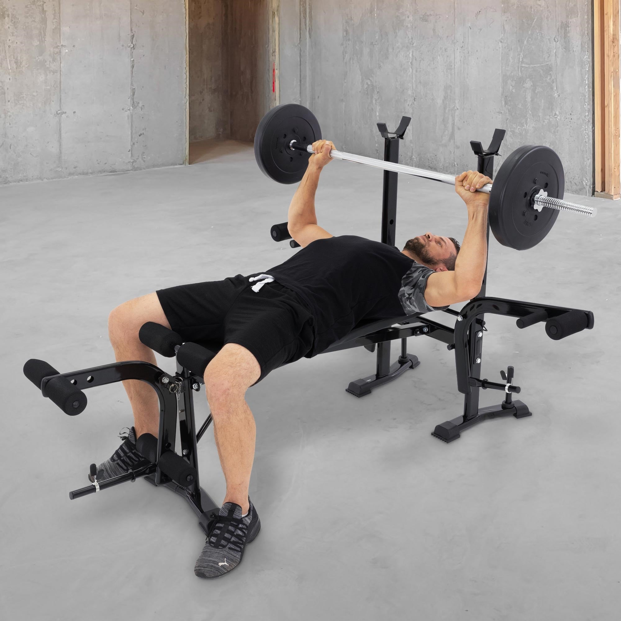 Osoba zvedá činku na fitness lavici.