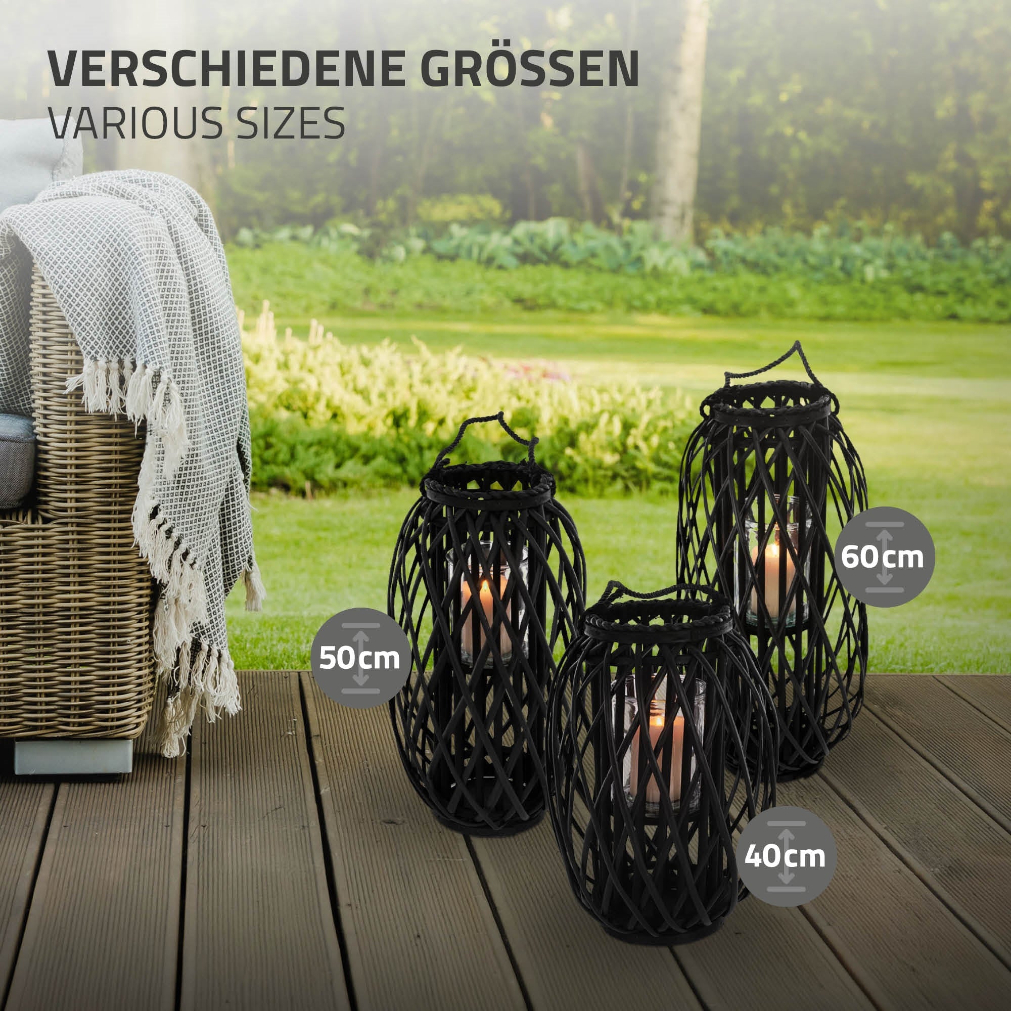 Trois lanternes noires de différentes tailles, avec des bougies, sur une terrasse en bois.