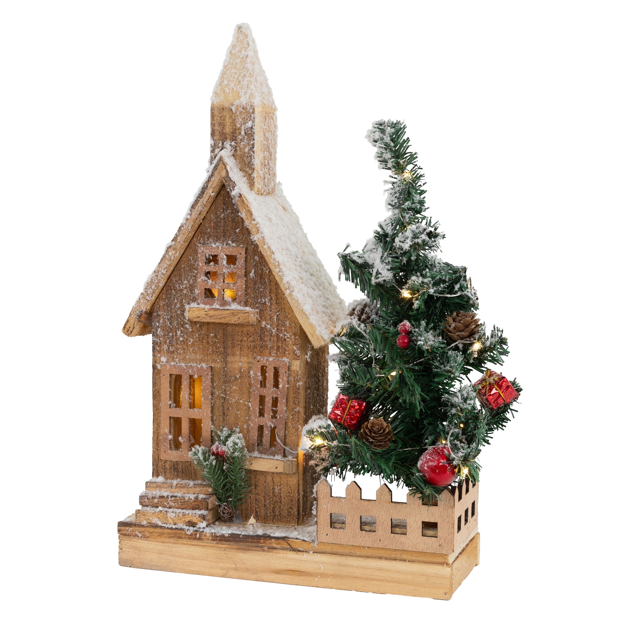 A wooden house with snow and a Christmas tree in front.