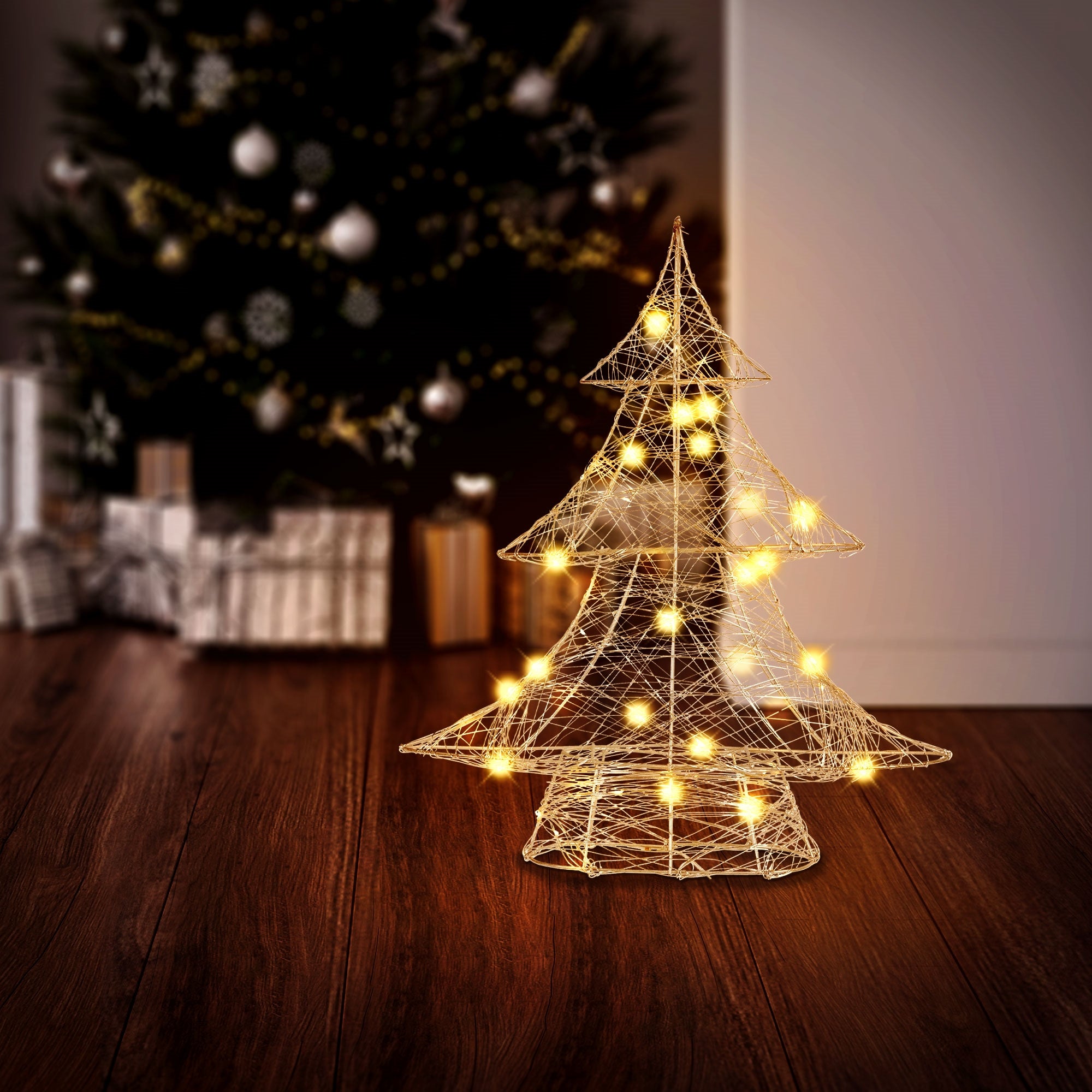 Ein beleuchteter Weihnachtsbaum vor einem Weihnachtsbaum im Hintergrund.