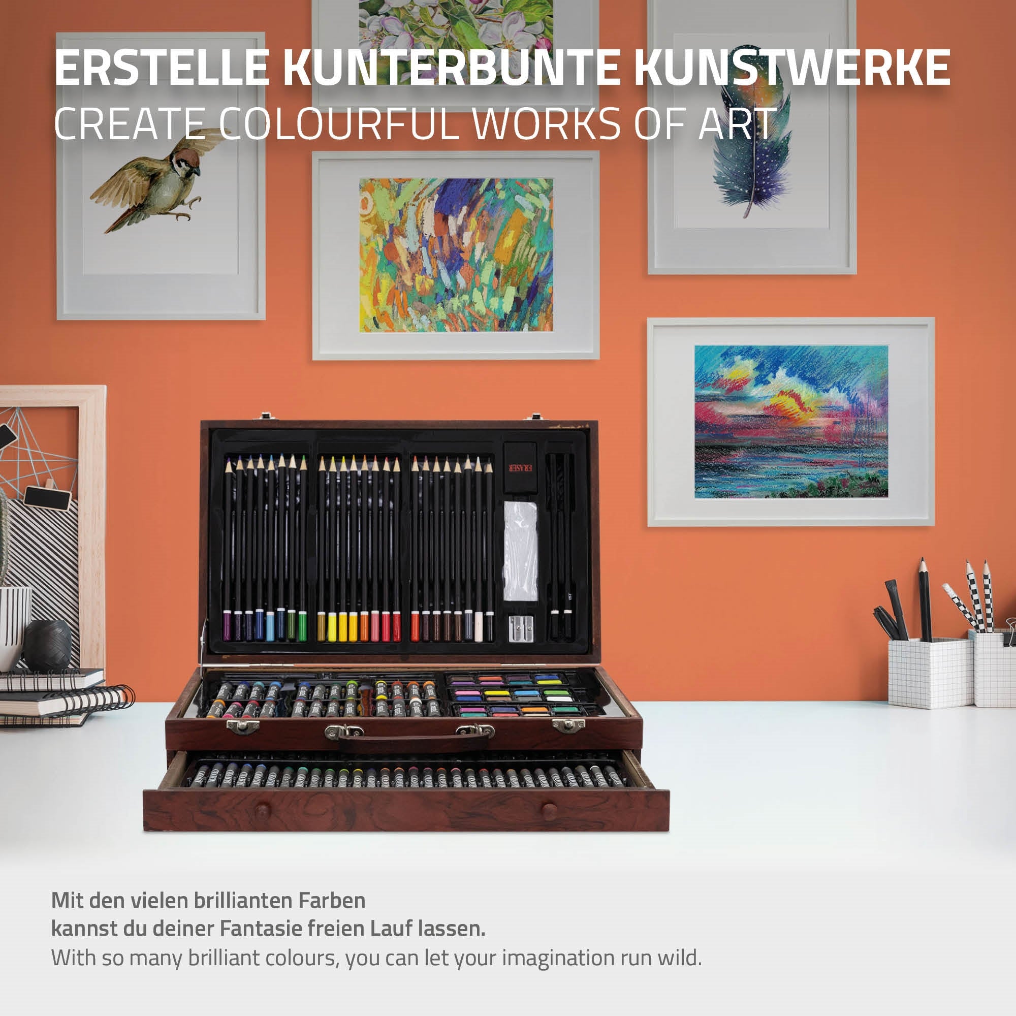 Ein Kunstset mit vielen Farben, das auf einem Tisch vor gerahmten Bildern steht.