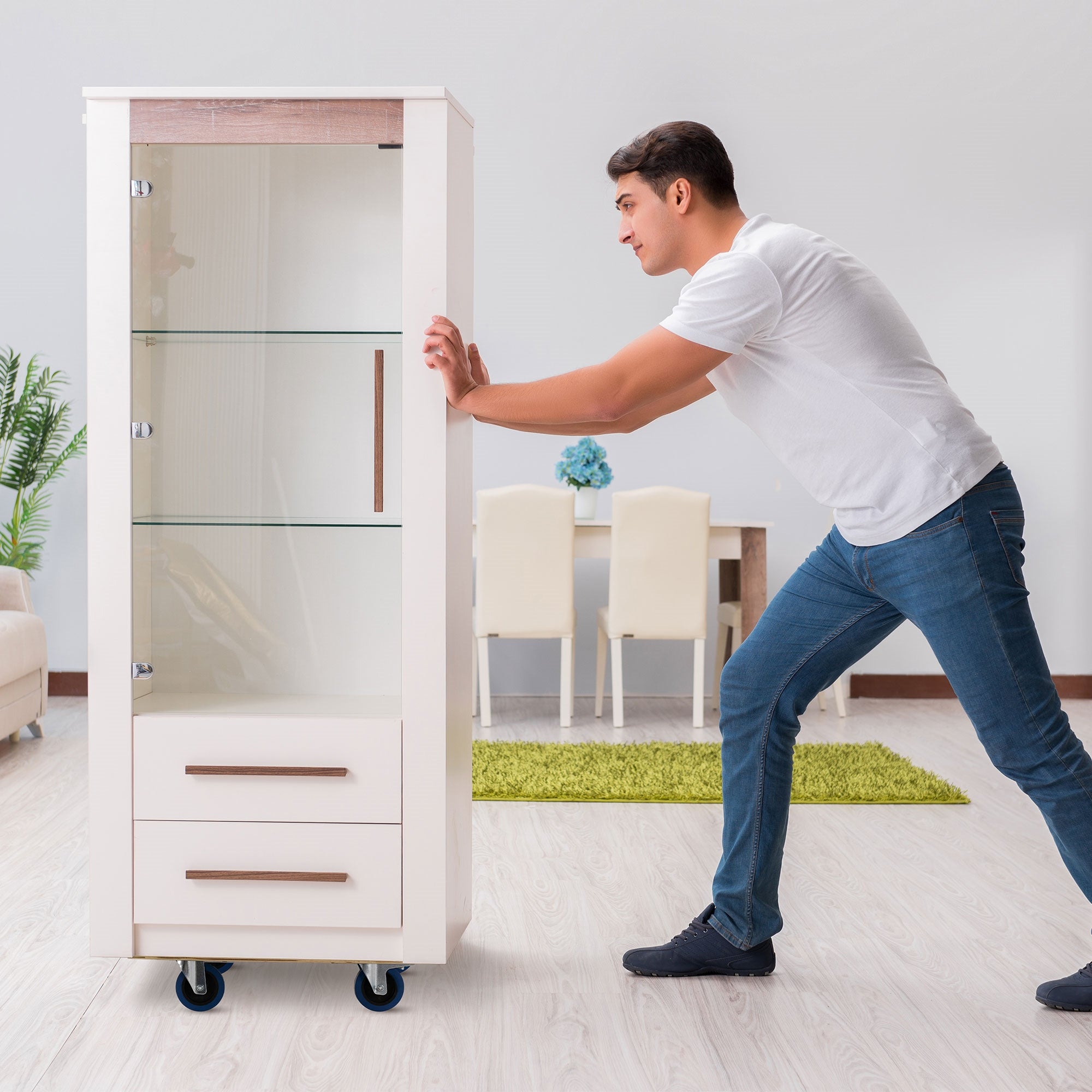 Un uomo spinge un mobile in una stanza luminosa con tappeto.