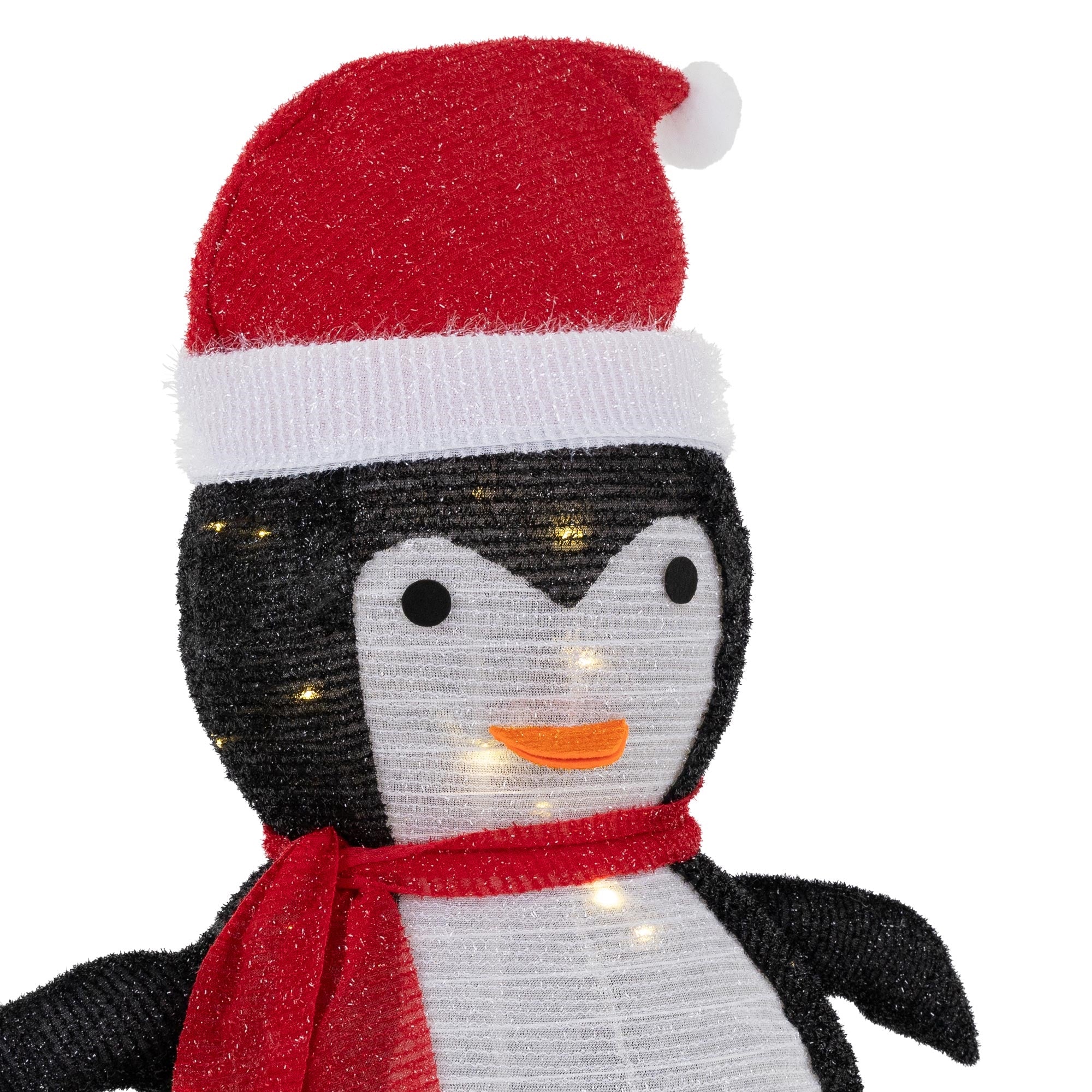 Dekoratiivinen pingviini punaisella hatulla ja huivilla, valaistu.