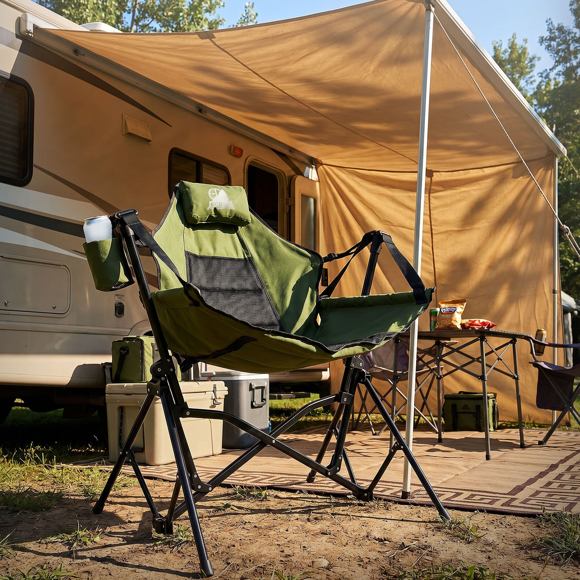 Ein grüner Campingstuhl vor einem Wohnmobil und einem Zelt.