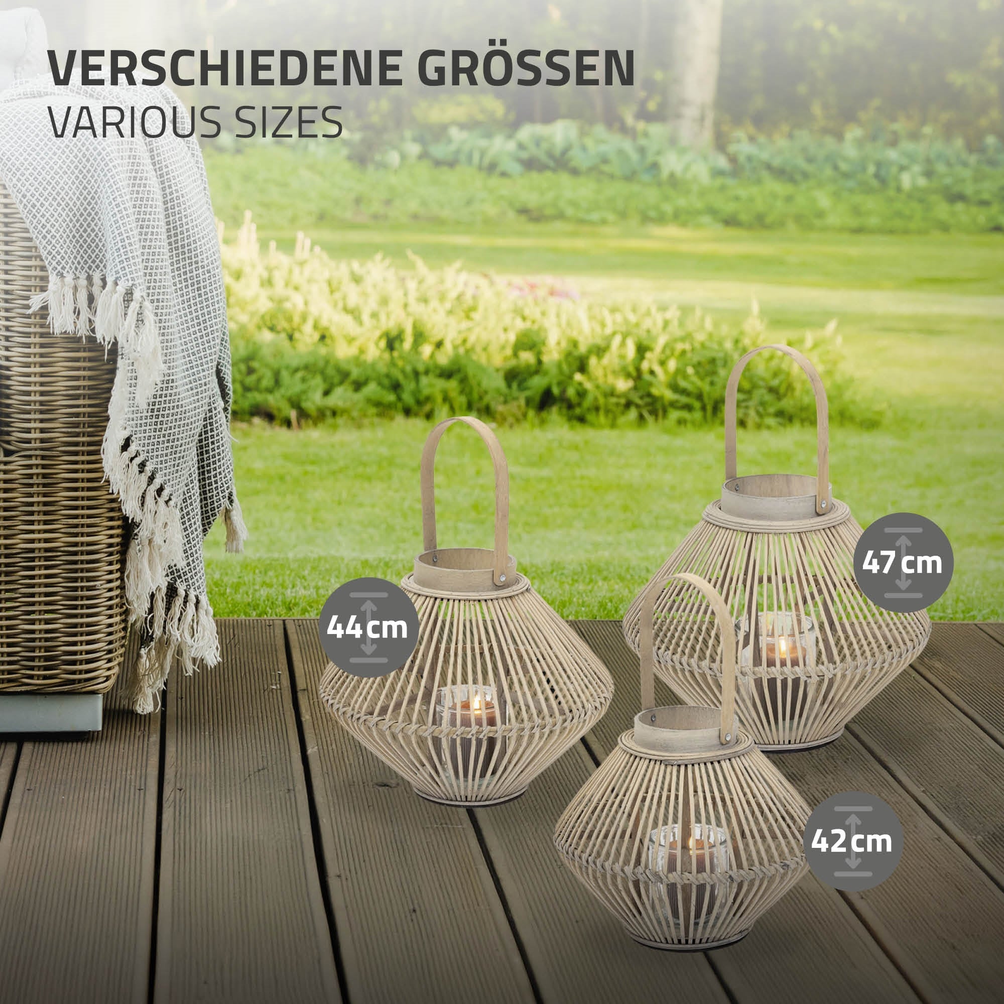 Drei Laternen in verschiedenen Größen auf einem Holzboden, mit grünem Rasen im Hintergrund.