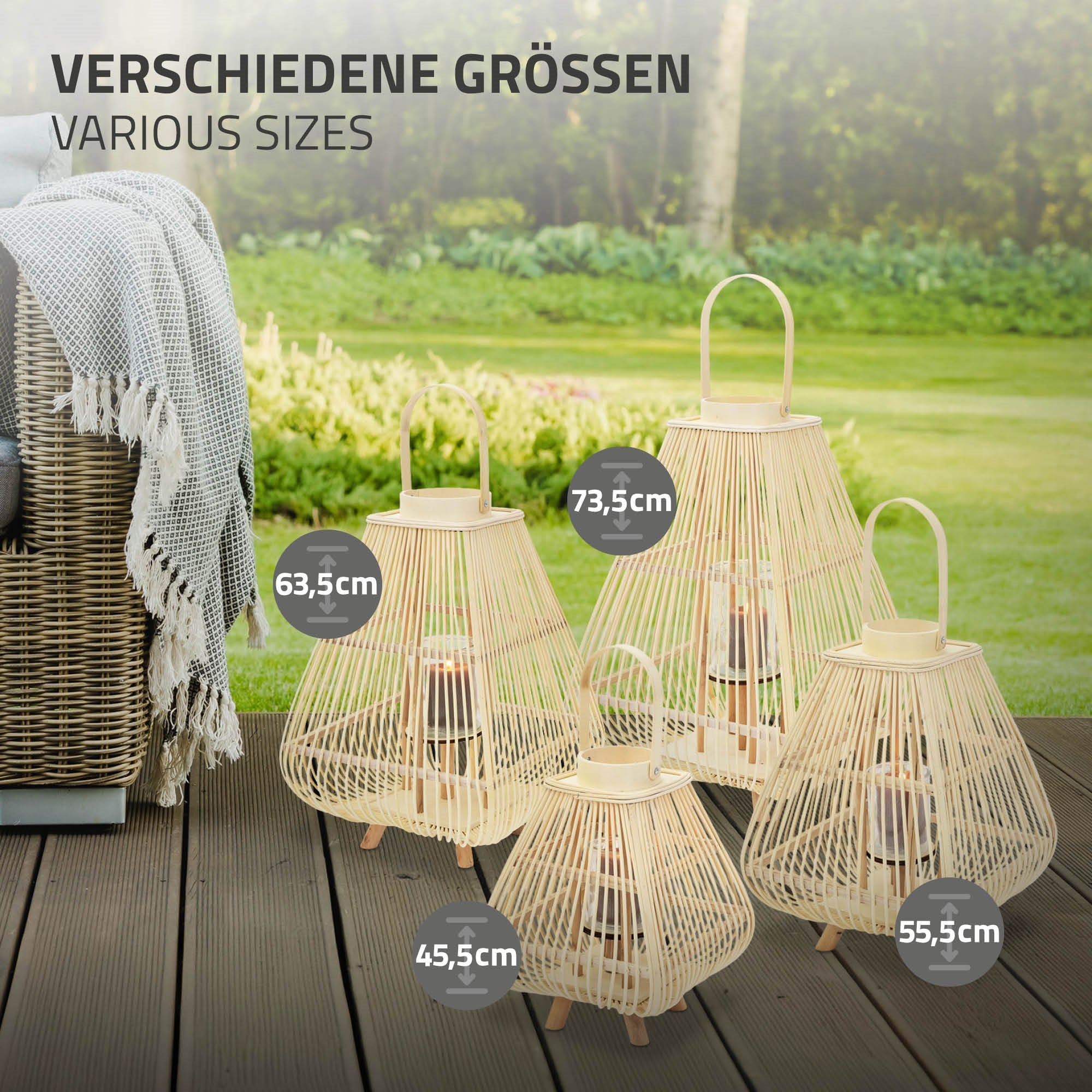 Vier Laternen in verschiedenen Größen stehen auf einem Rasen vor einem Sofa.