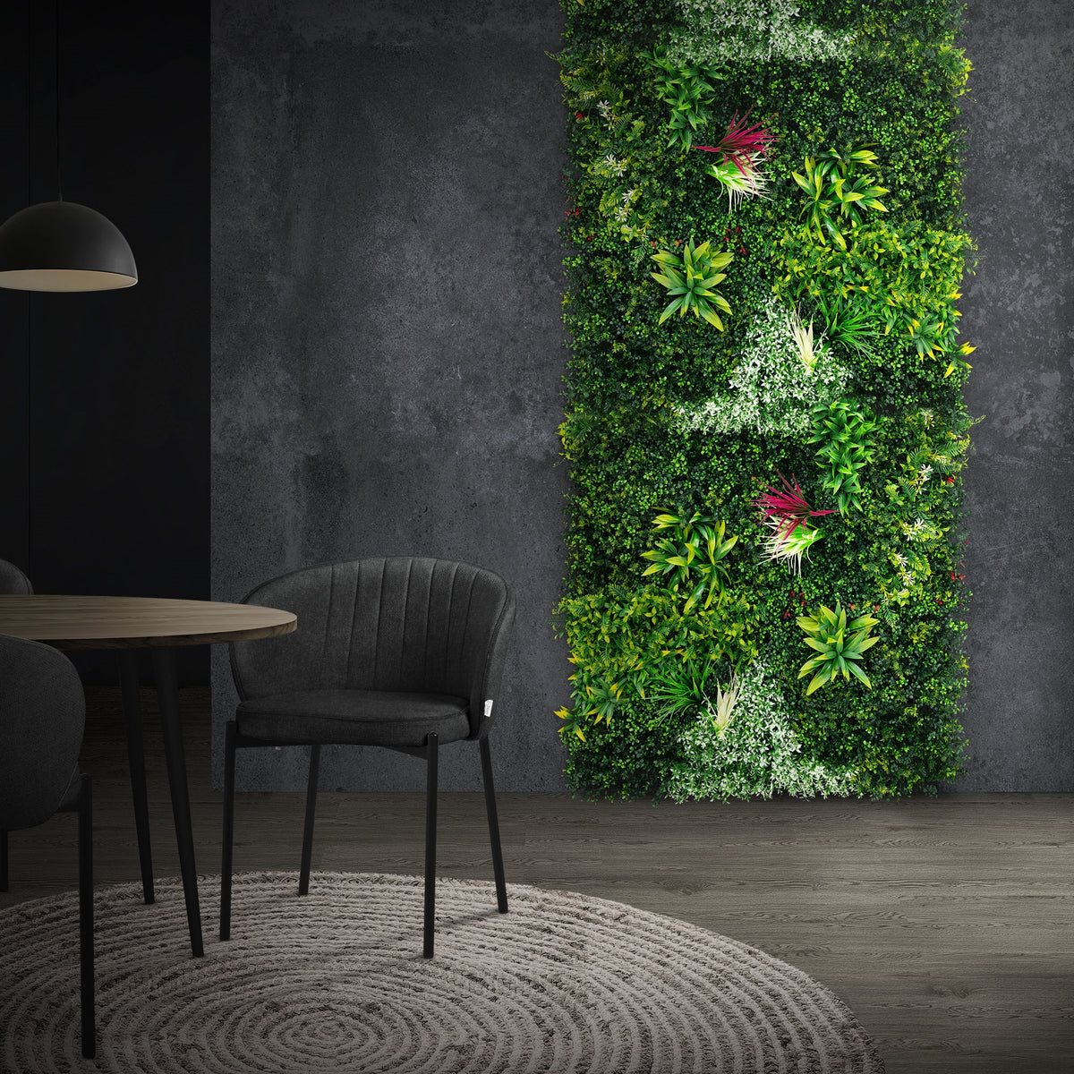Espace avec un haut mur de plantes, une table et un tapis rond.