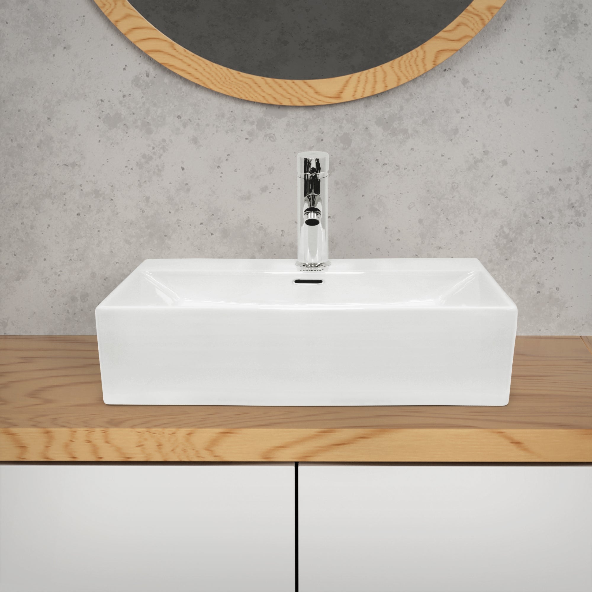 Lavabo rectangulaire blanc sur un meuble en bois.