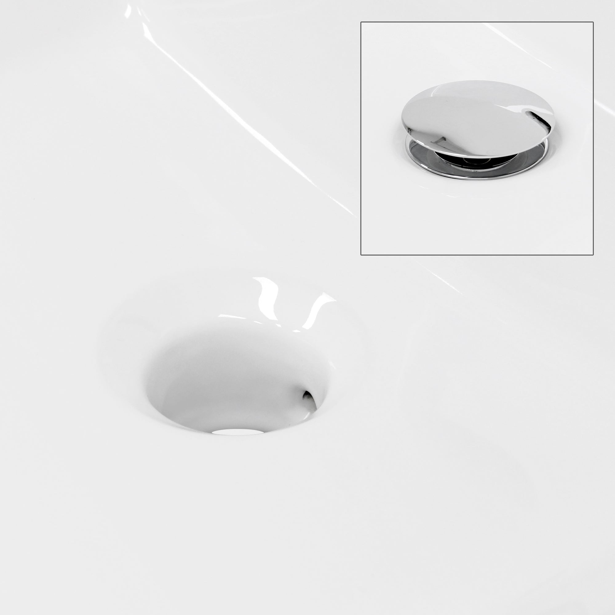 Lavabo blanc avec un bouchon d'évacuation chromé.