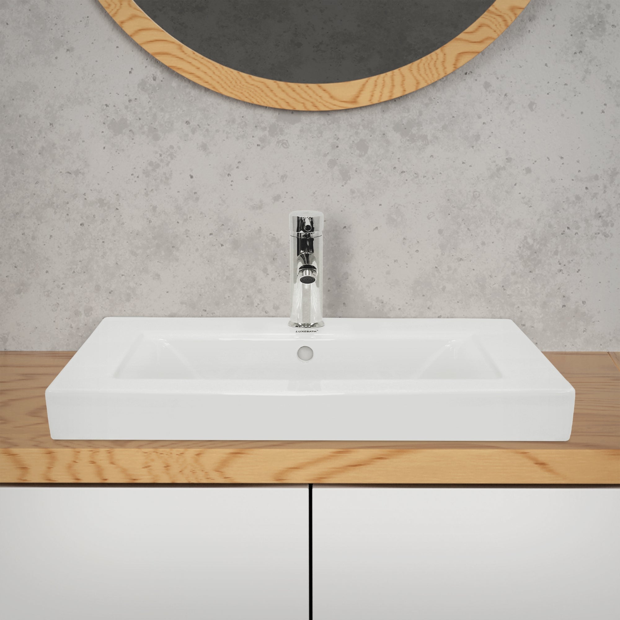 Weißes Waschbecken auf einem Holzregal vor einer grauen Wand mit runder Spiegel.