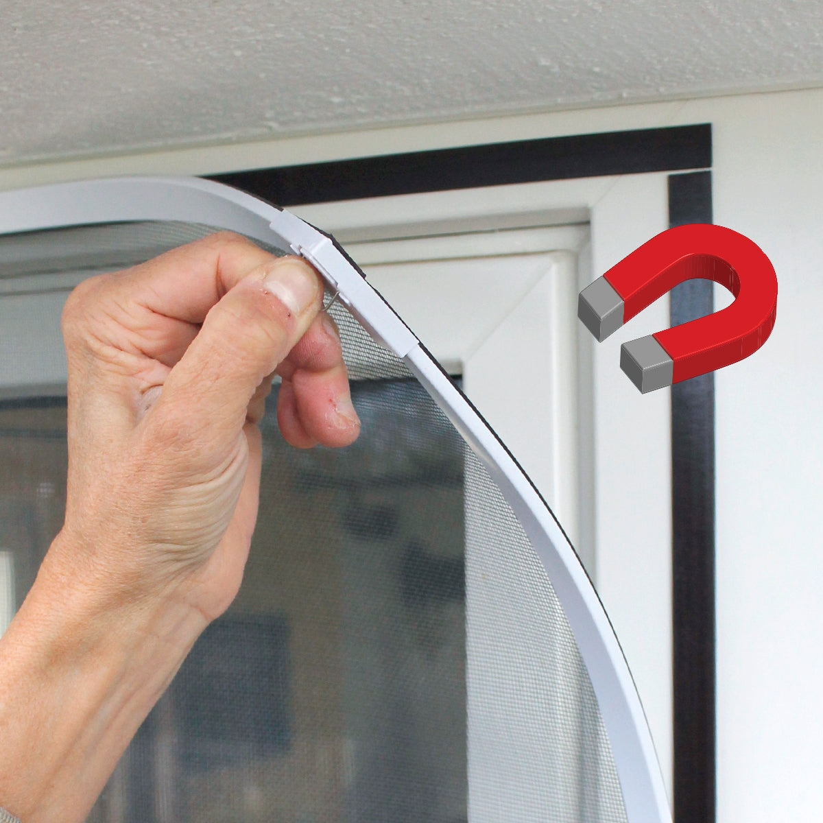 Hands attaching an insect screen with magnets to a window.