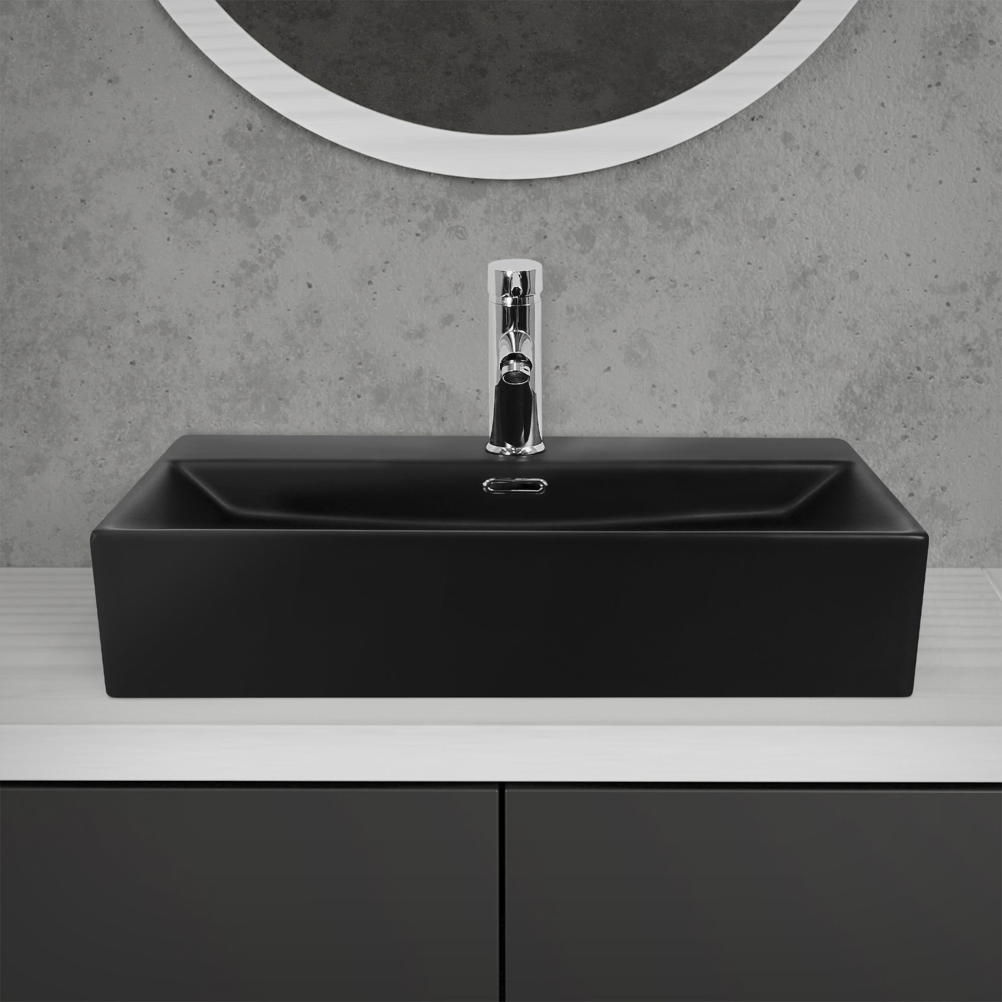 Lavabo noir avec robinet brillant sur une surface blanche.