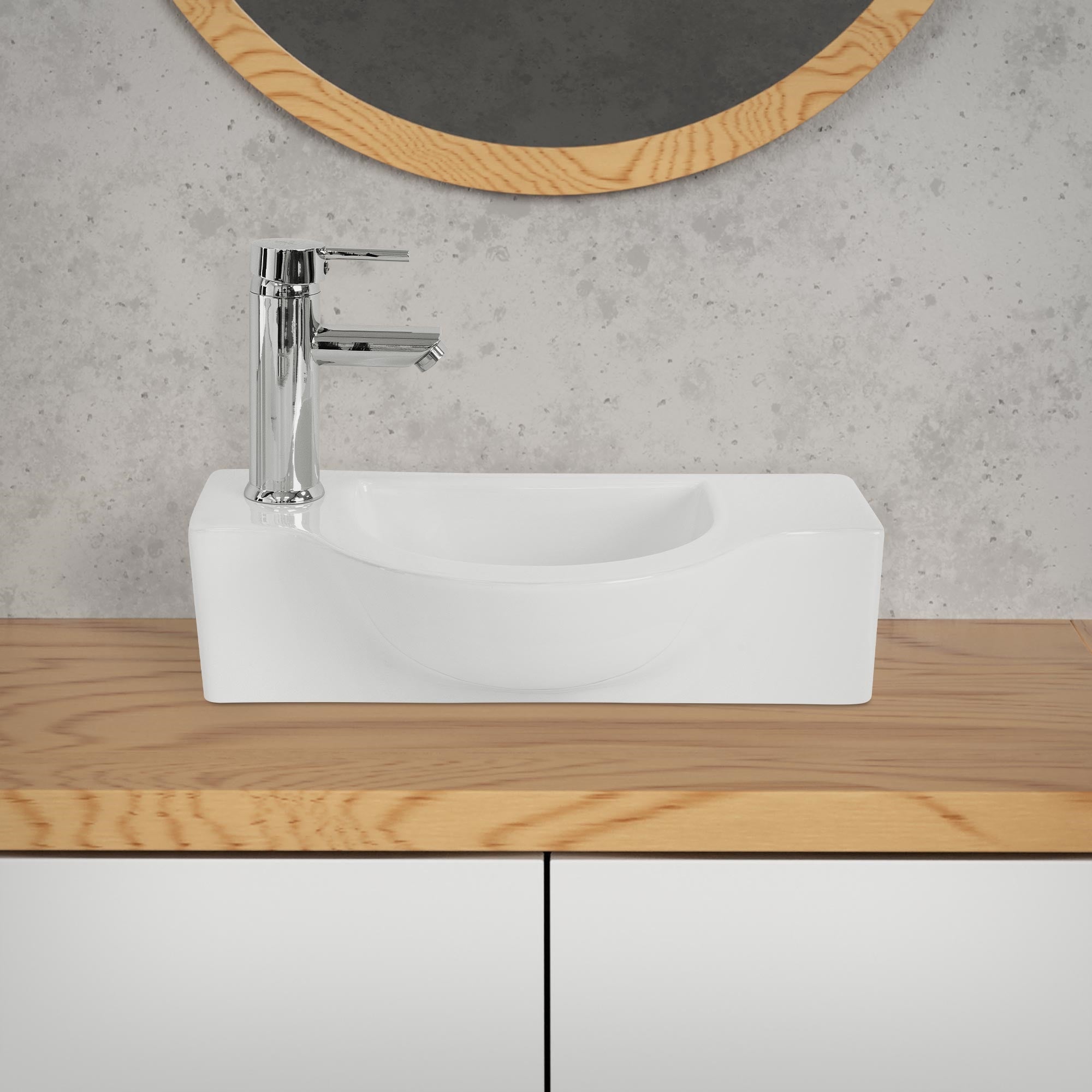 Waschbecken auf Holzablage mit verchromtem Wasserhahn und Spiegel.