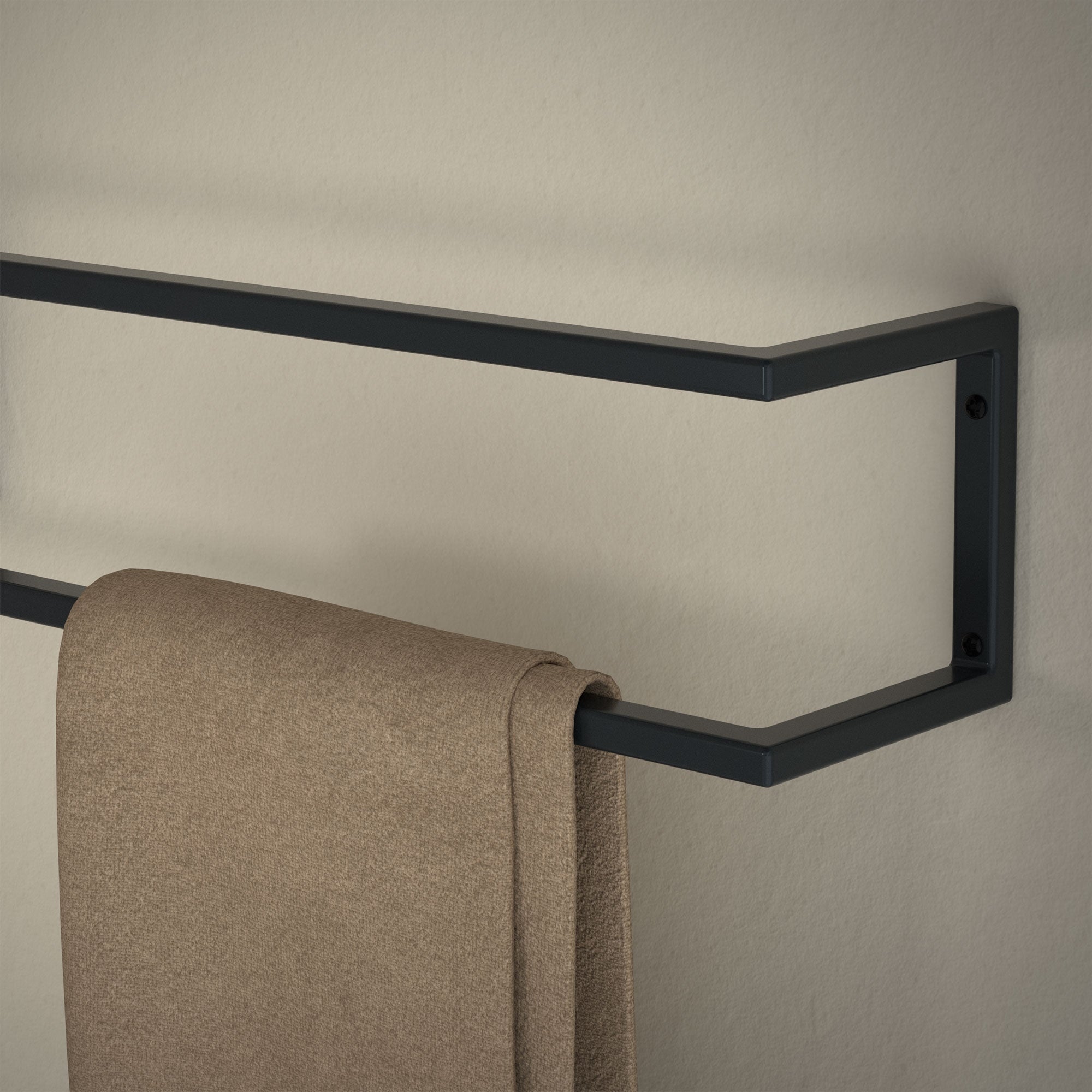 Porte-serviettes en métal sur un mur avec une serviette brune.