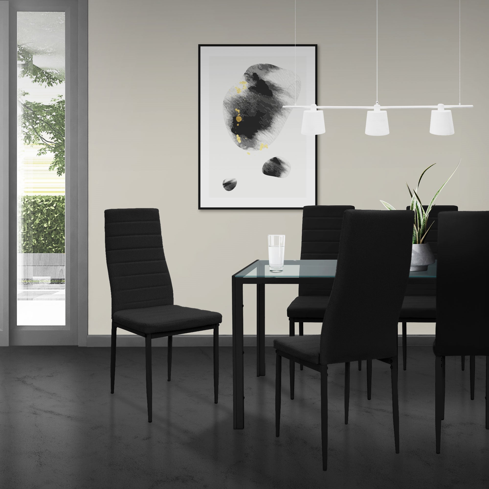 Comedor con mesa negra y cuatro sillas negras, obra de arte en la pared.