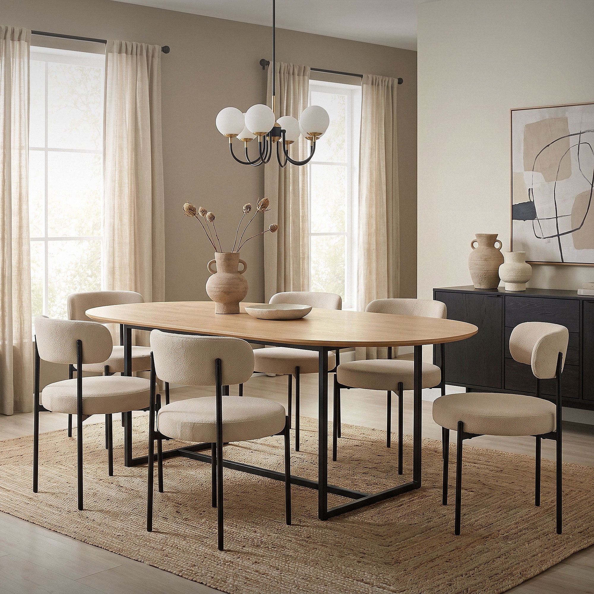 Un comedor con mesa ovalada, sillas beige y un jarrón sobre la mesa.