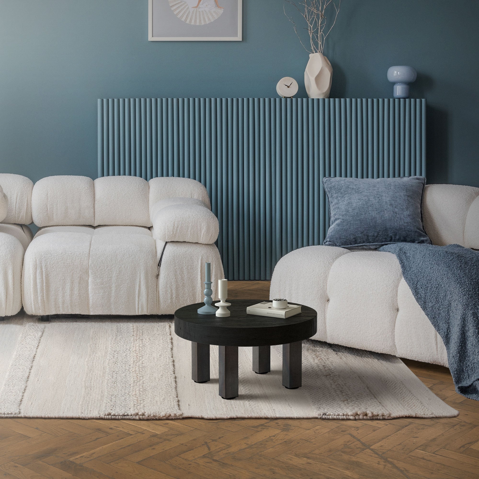 Light sofa set with a round table on a carpet.