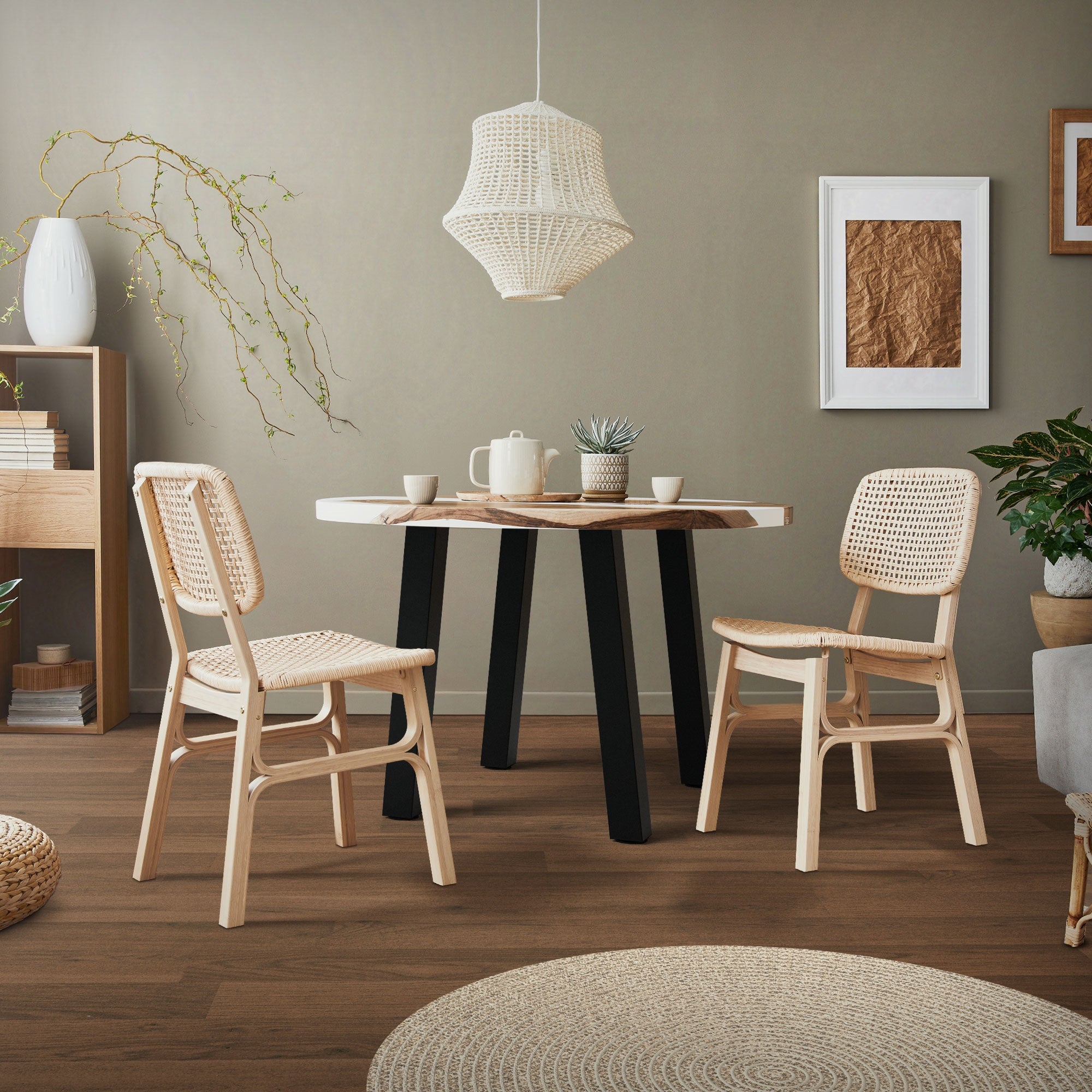 Espace repas avec une table ronde, deux chaises et un luminaire suspendu.