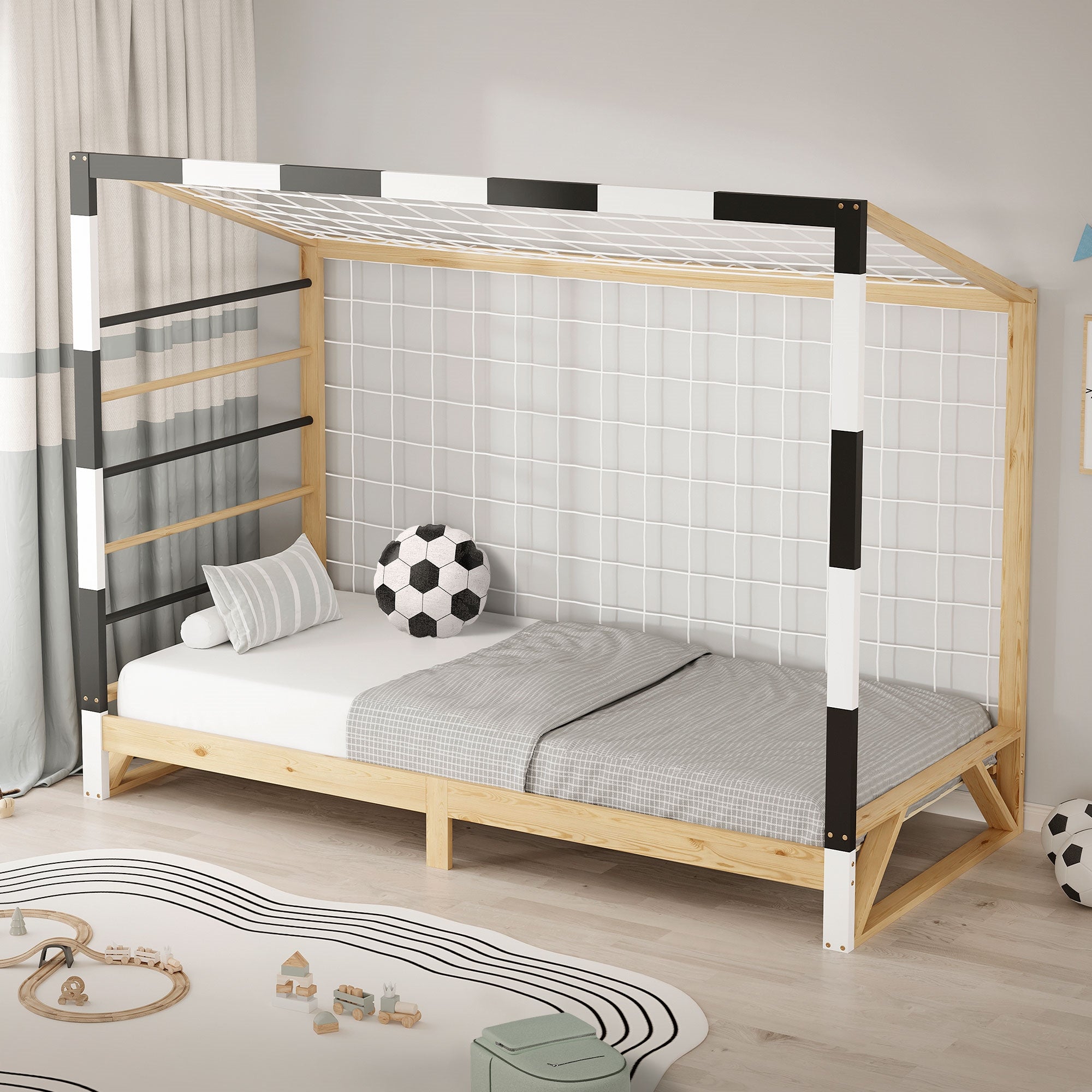 Ein Bett mit einem Gitter, einem Fußball und einem grauen Kissen.