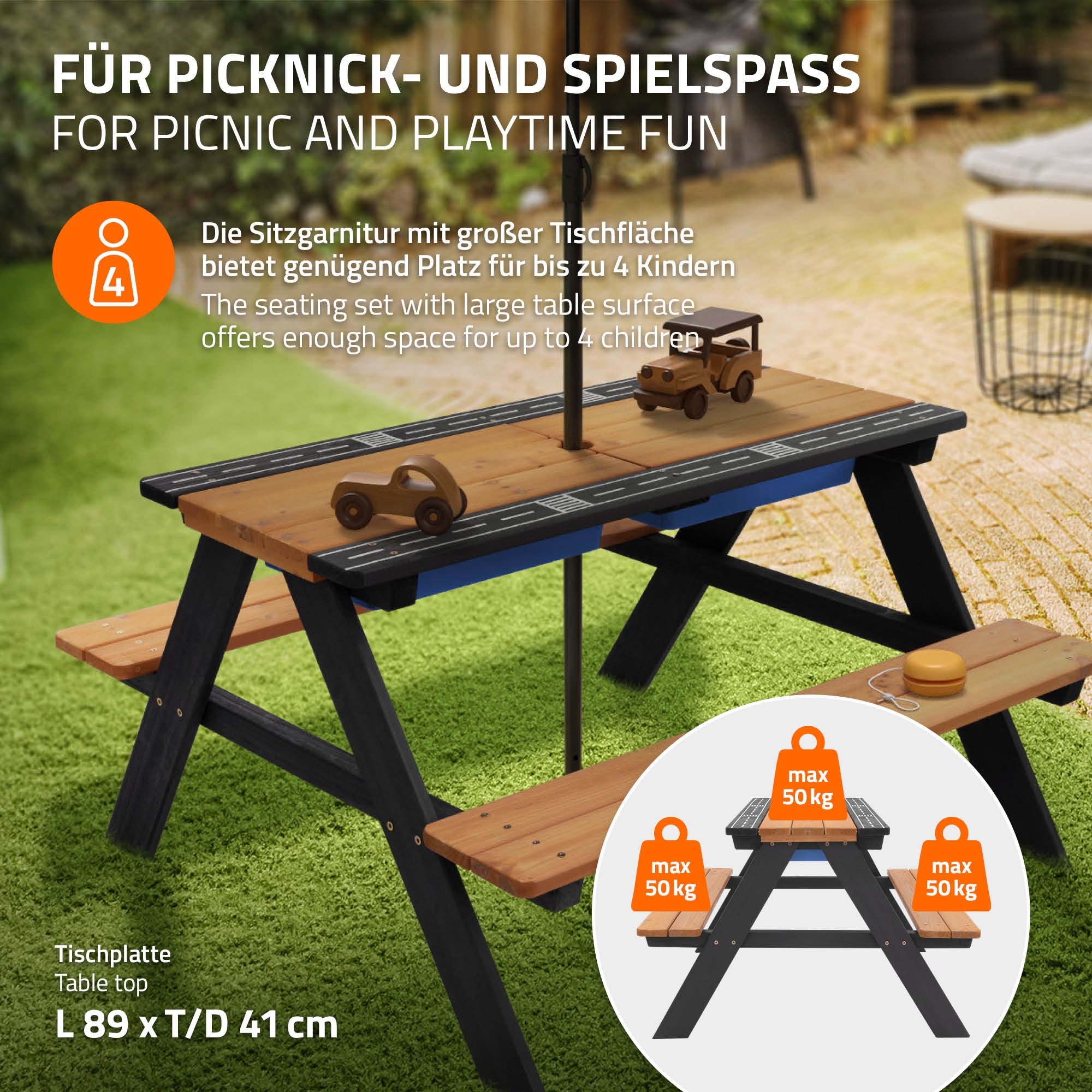Holztisch mit Bänken, Sonnenschirm und Spielzeug auf einer Wiese.