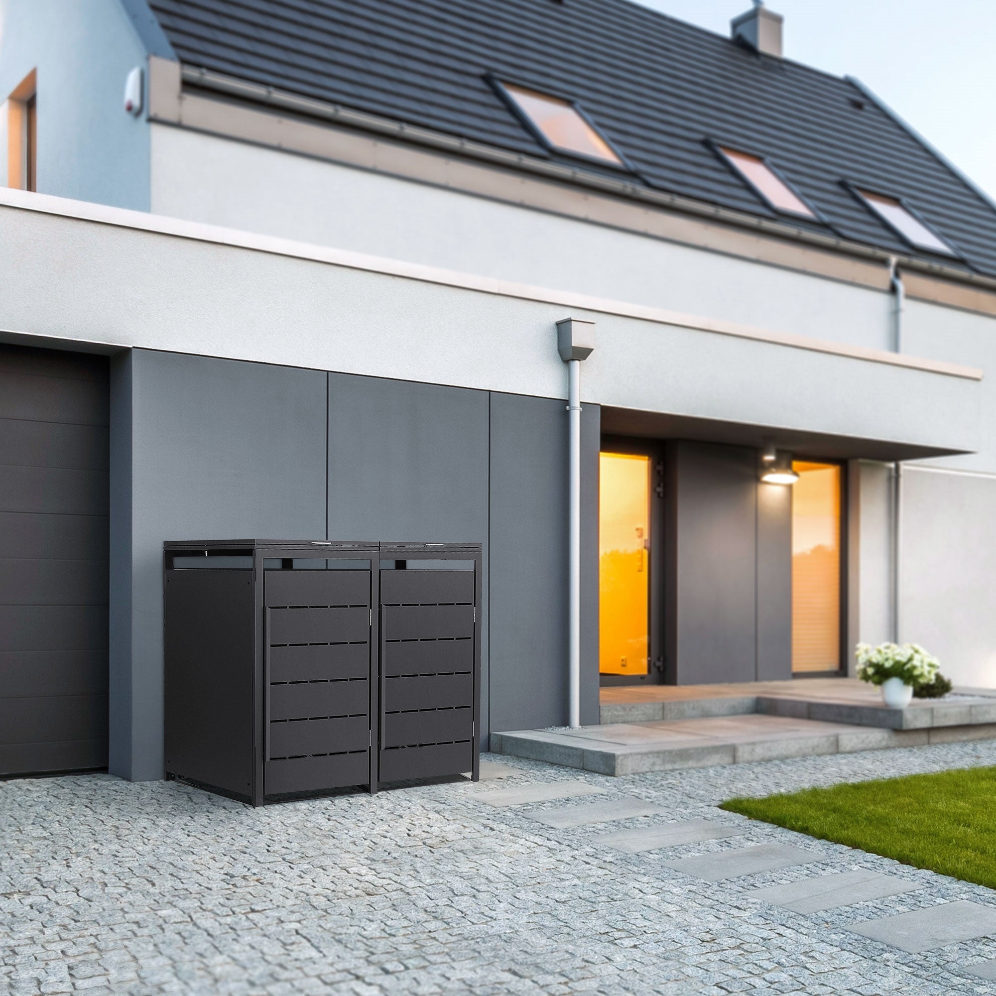 Due box per bidoni della spazzatura grigi davanti a una casa moderna con giardino.