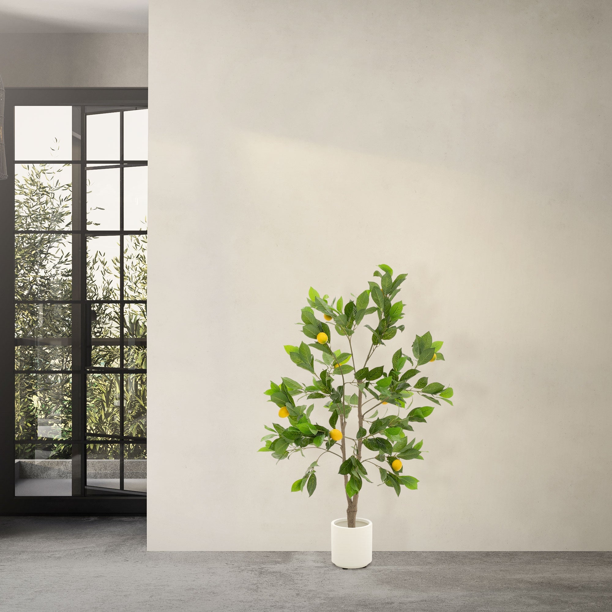 Artificial tree with lemons in a room, window in the background.