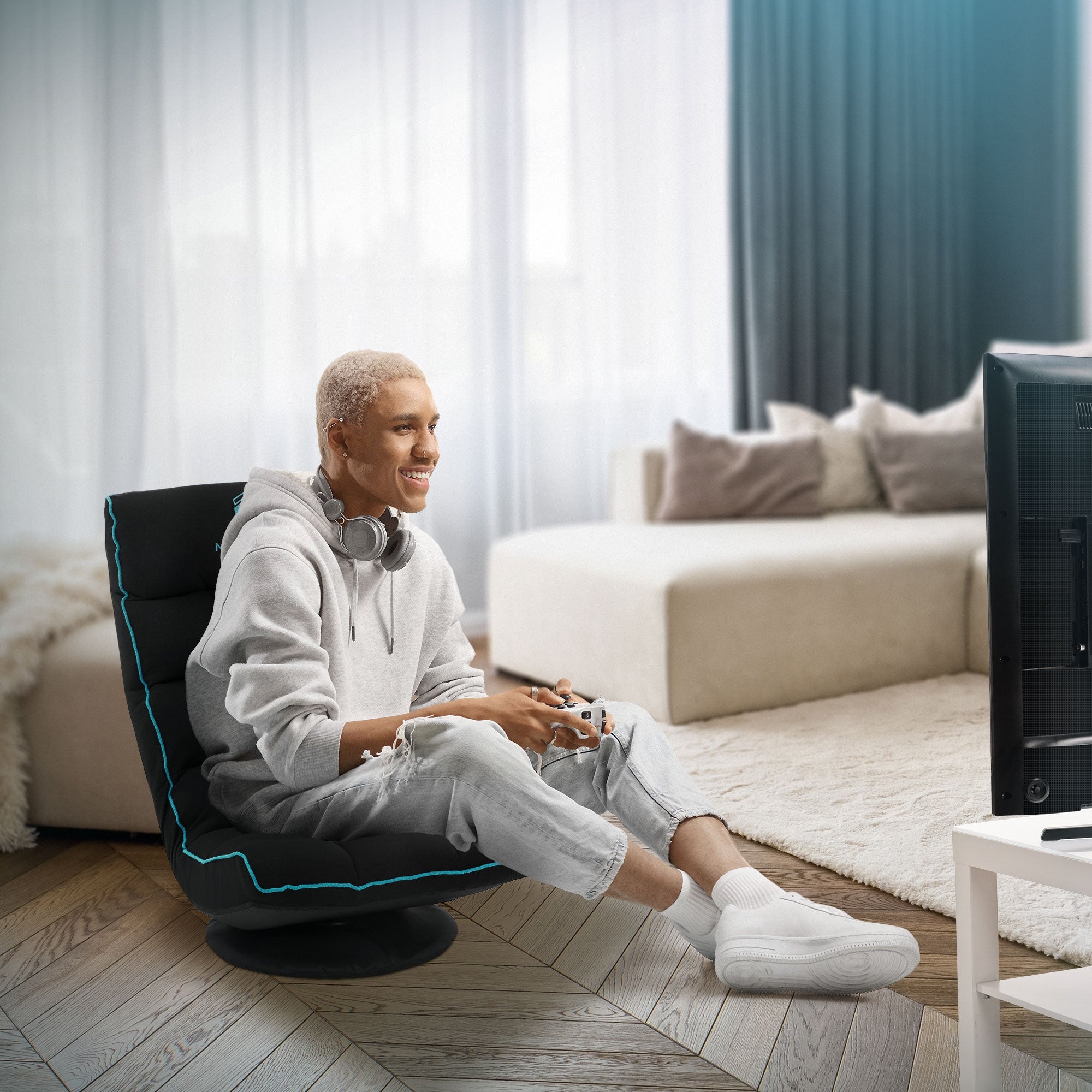 Jeune homme assis sur une chaise de gaming en train de jouer à des jeux vidéo.