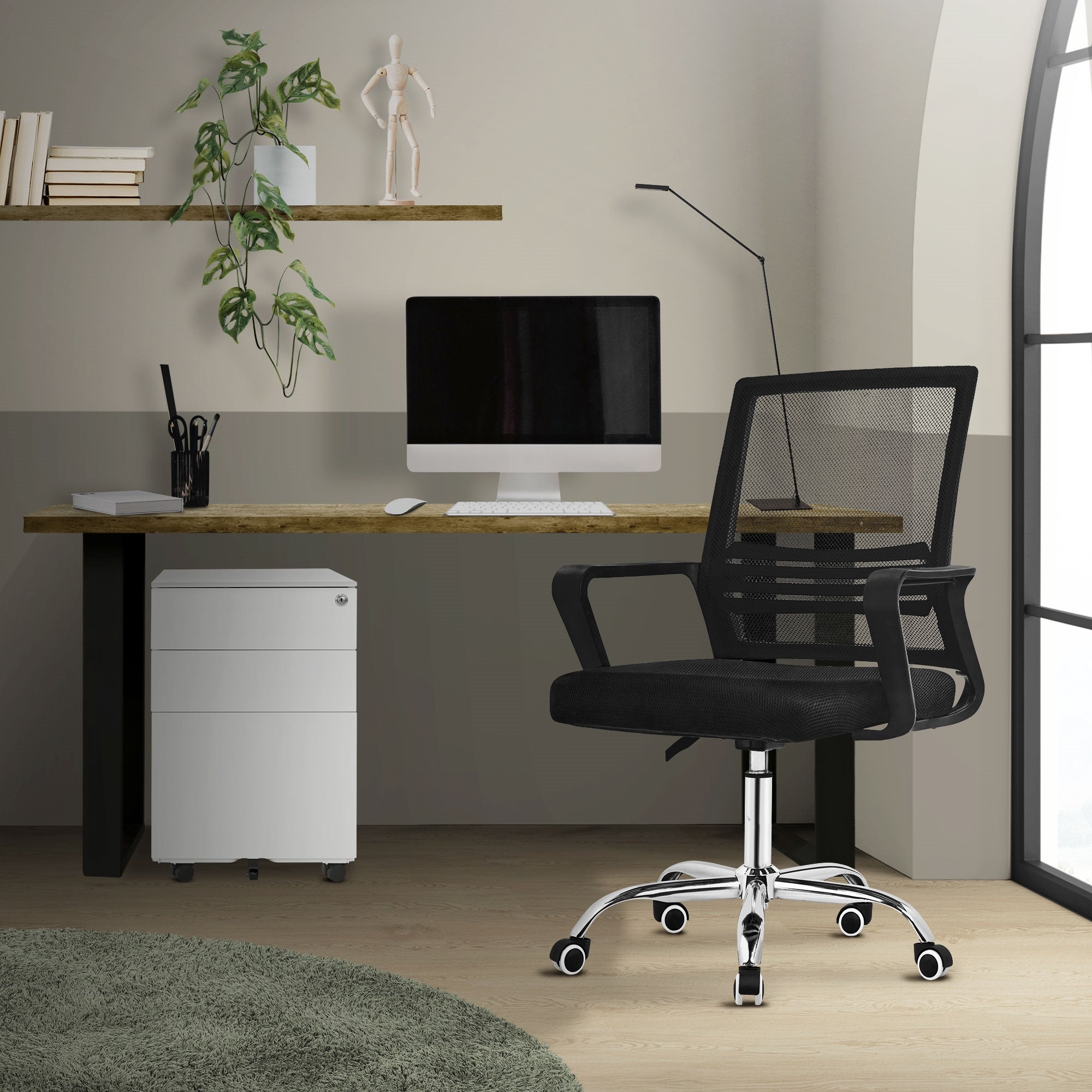 Büro mit Schreibtisch, Computer und schwarzem Bürostuhl in einem modernen Raum.