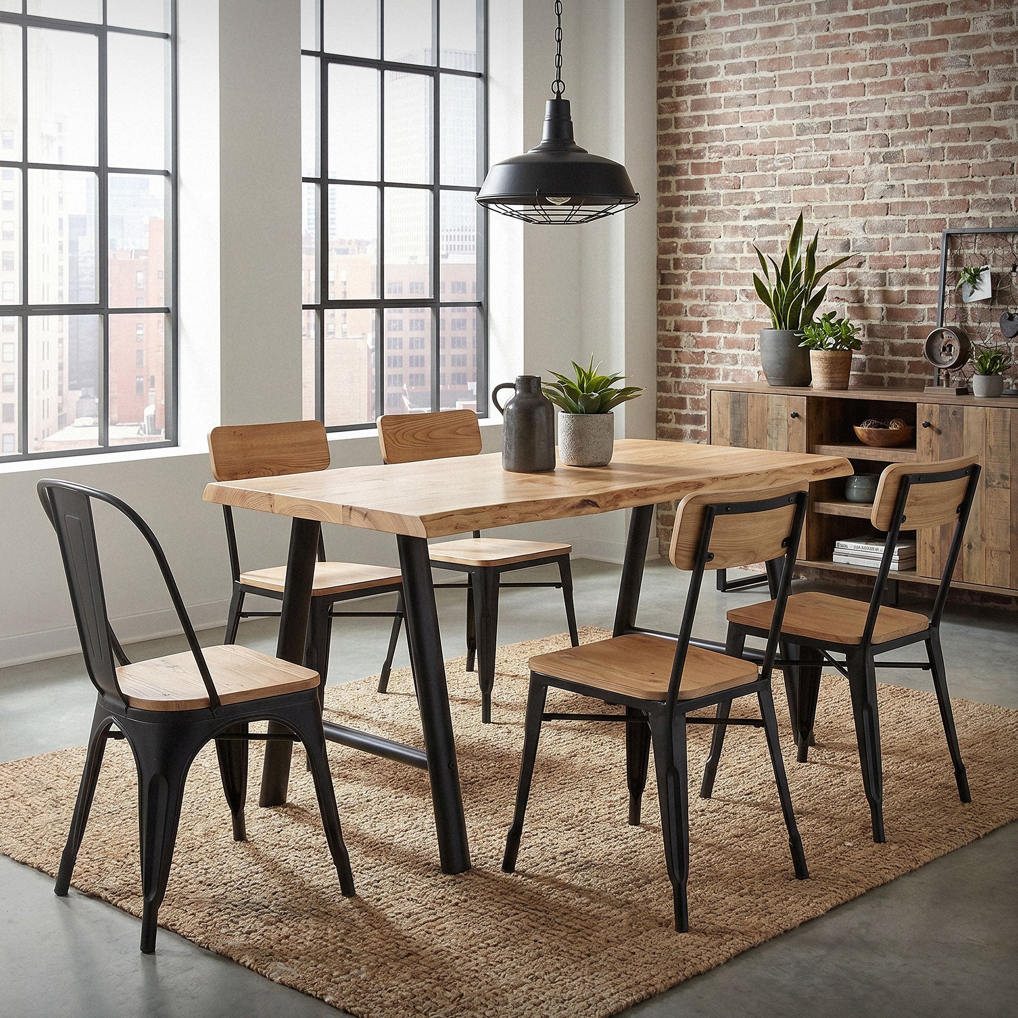 Une salle à manger avec une table en bois et cinq chaises devant de grandes fenêtres.