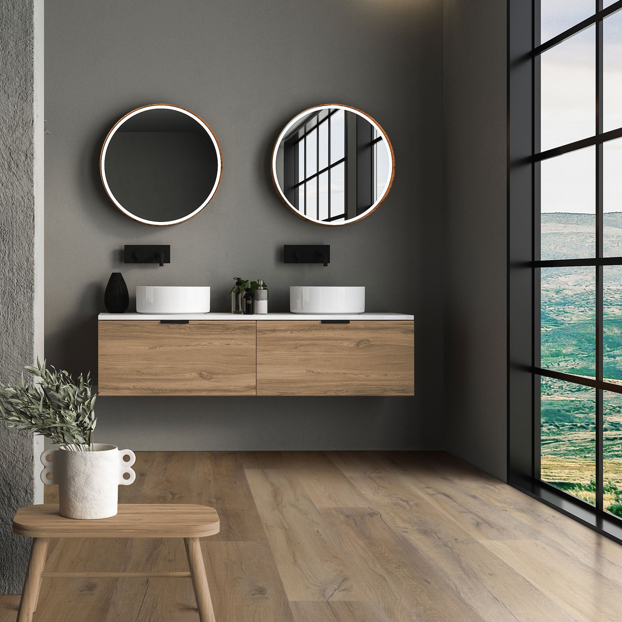 Modern badkamer met twee ronde spiegels en houten wastafel voor grote ramen.