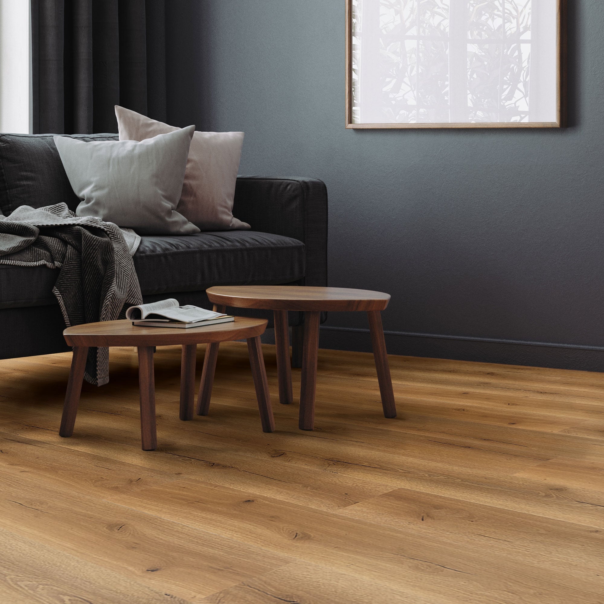 Sofa s polštáři a dvěma malými stoly na dřevěné podlaze v obývacím pokoji.