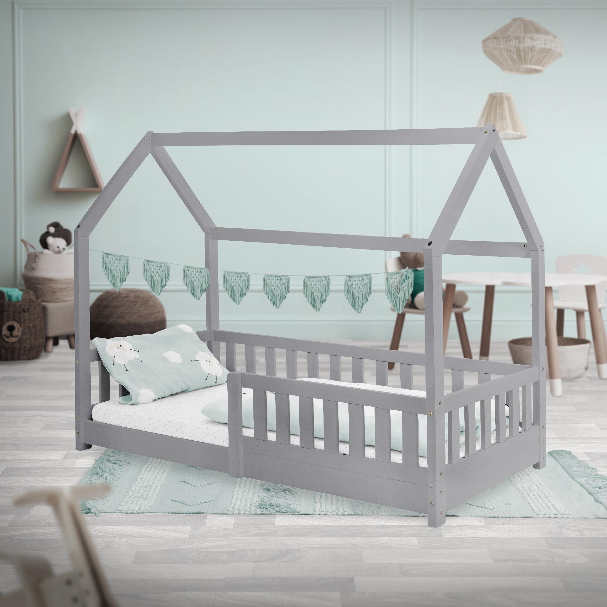 Gray painted bed in the children's room, with pillows and decoration.
