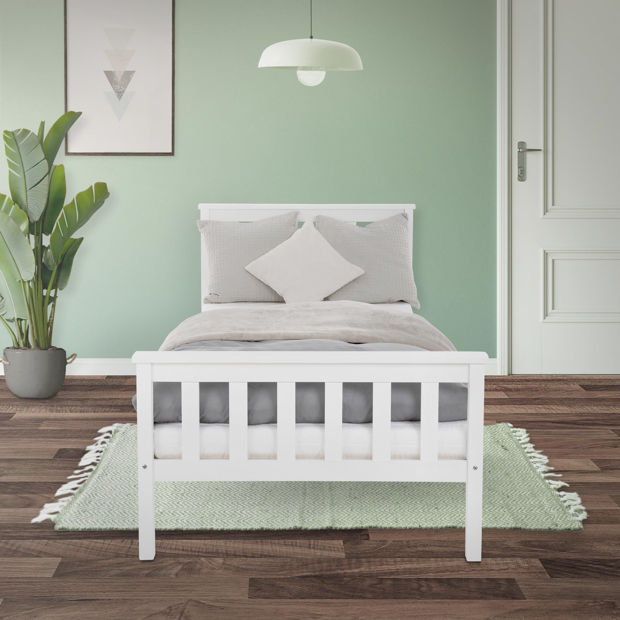 Weißes Bett im Raum mit grüner Wand und Pflanzen.