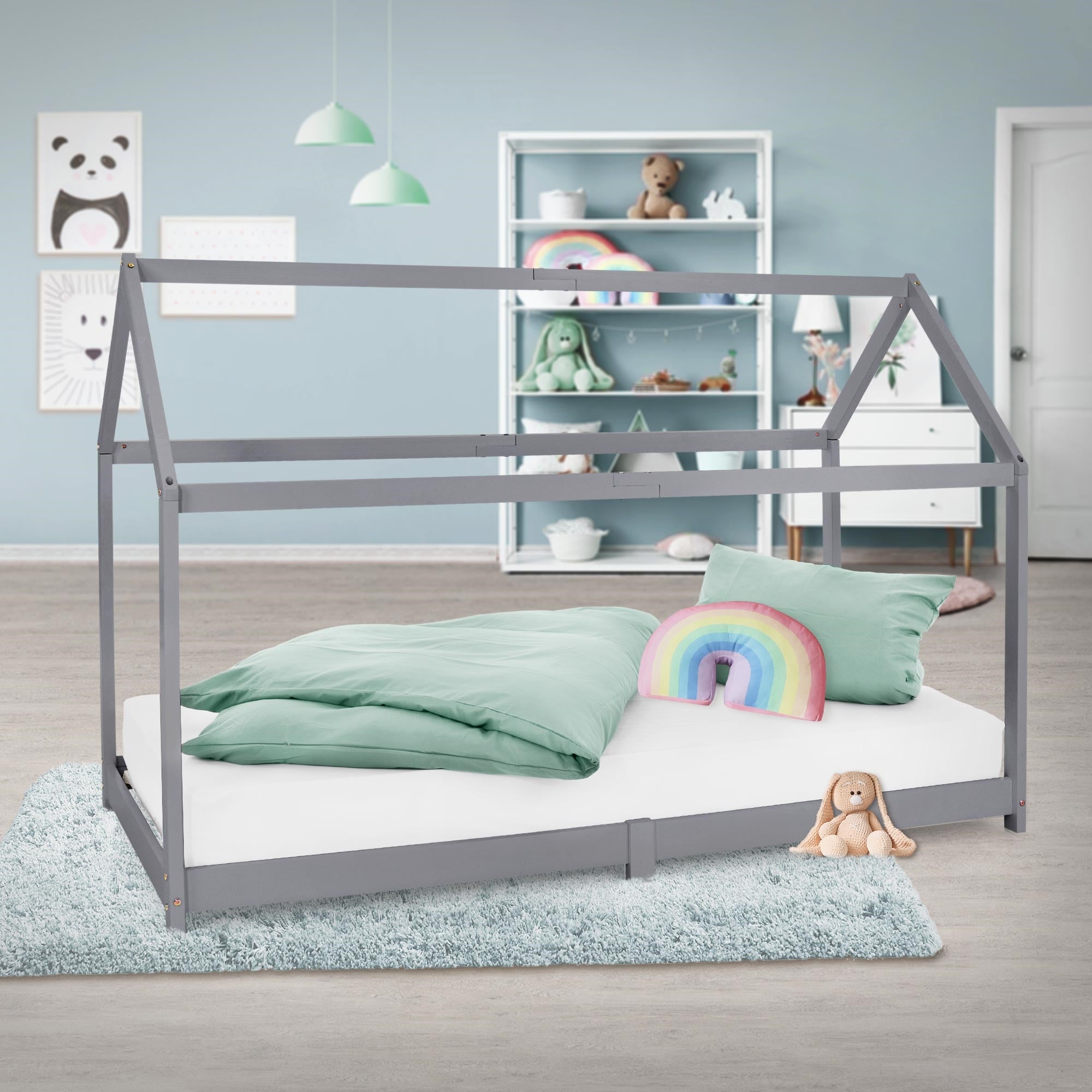 Bed with pillow and blanket in a bright room with toy shelf.