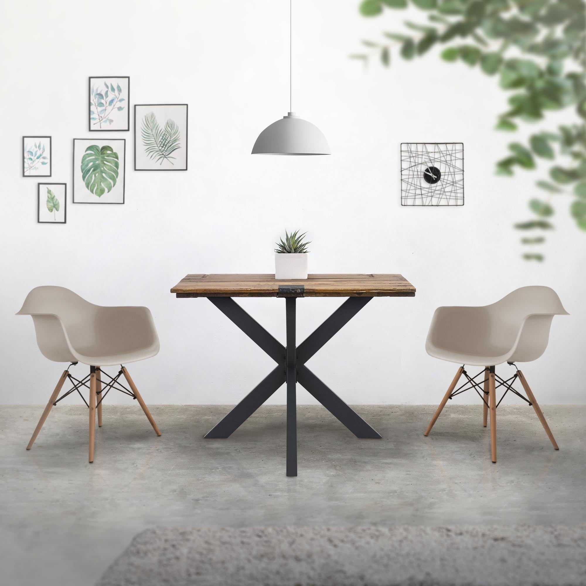 Comedor con mesa, dos sillas y cuadros en la pared.