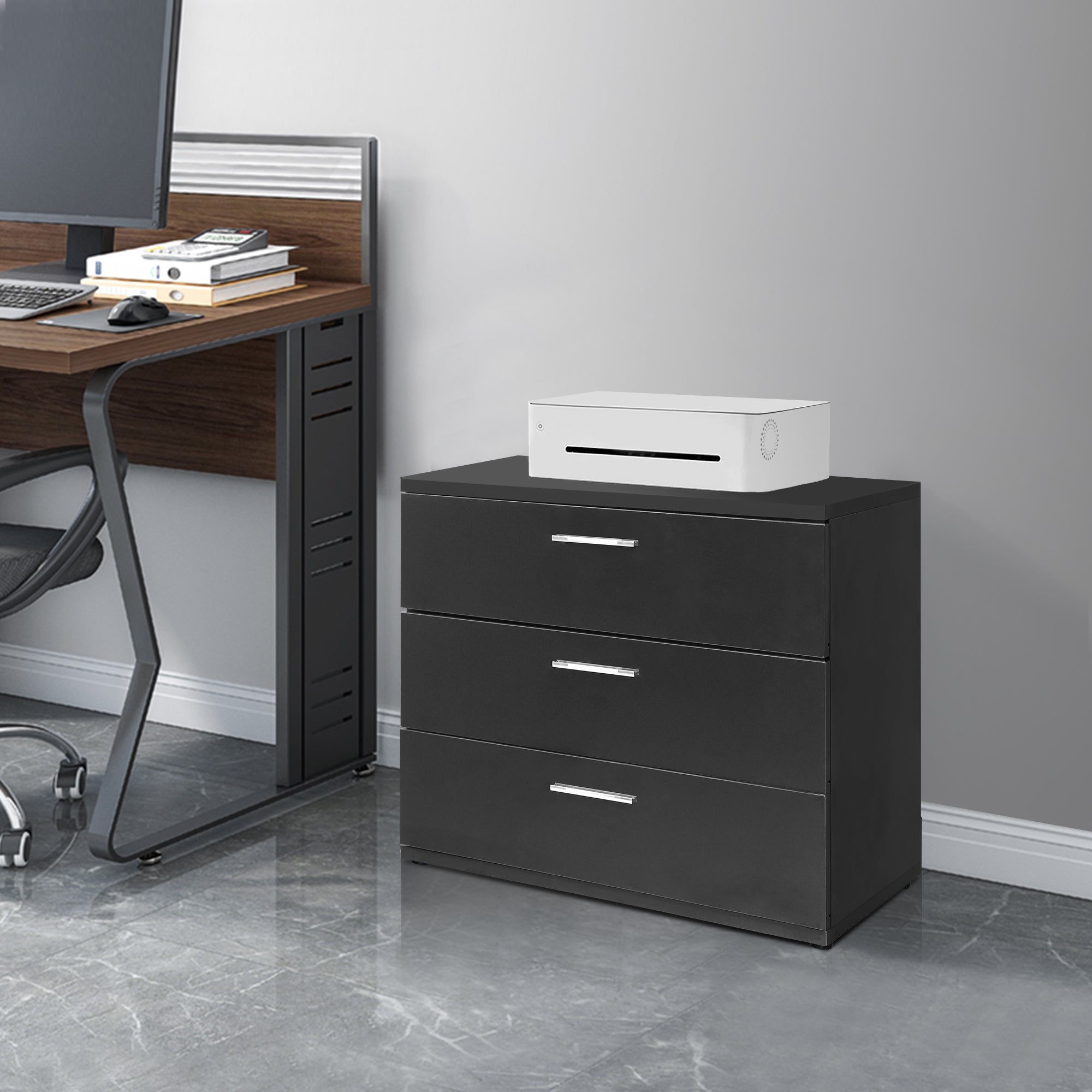 Black cabinet with three drawers and a white device on top.