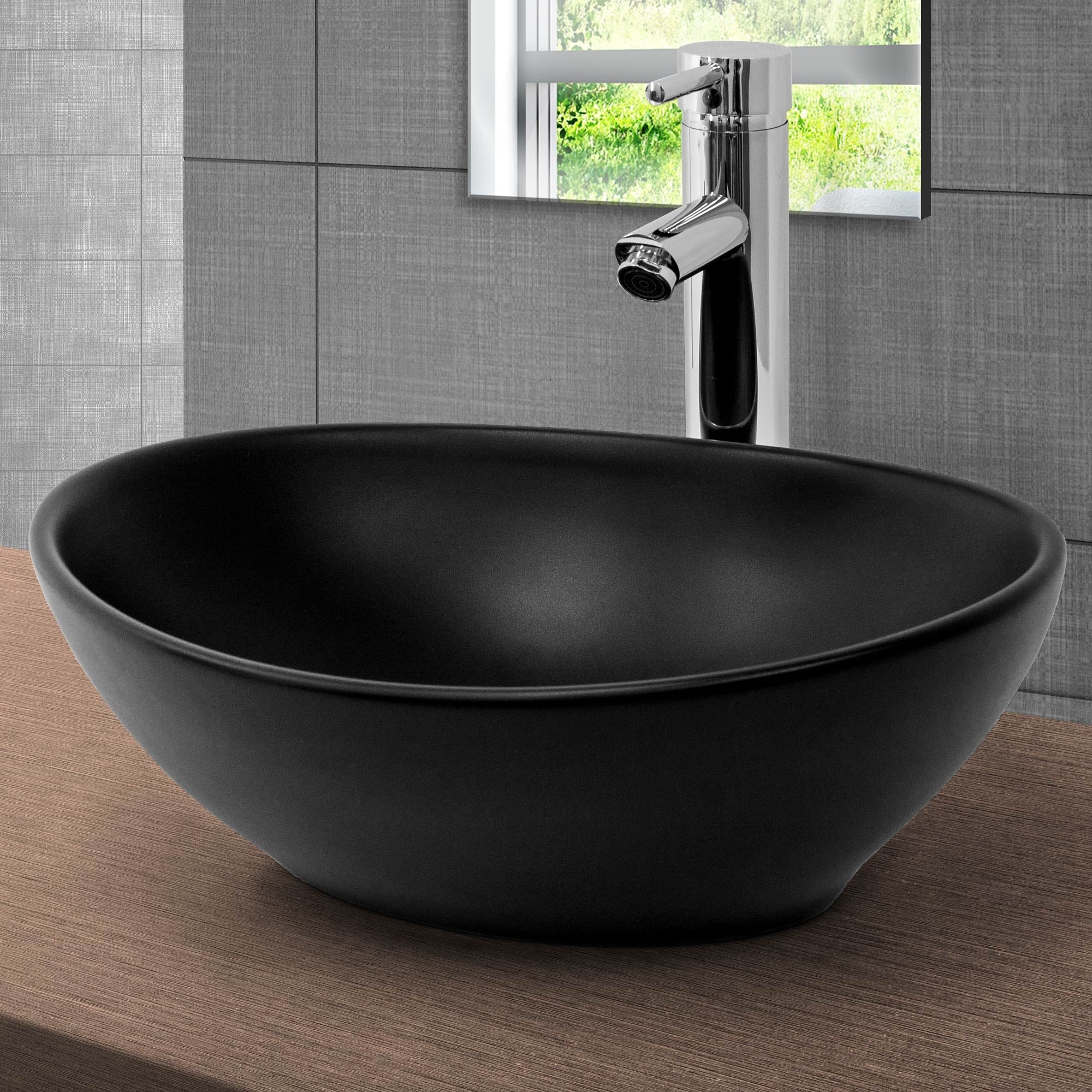 Round black sink on a wooden shelf in front of a window.