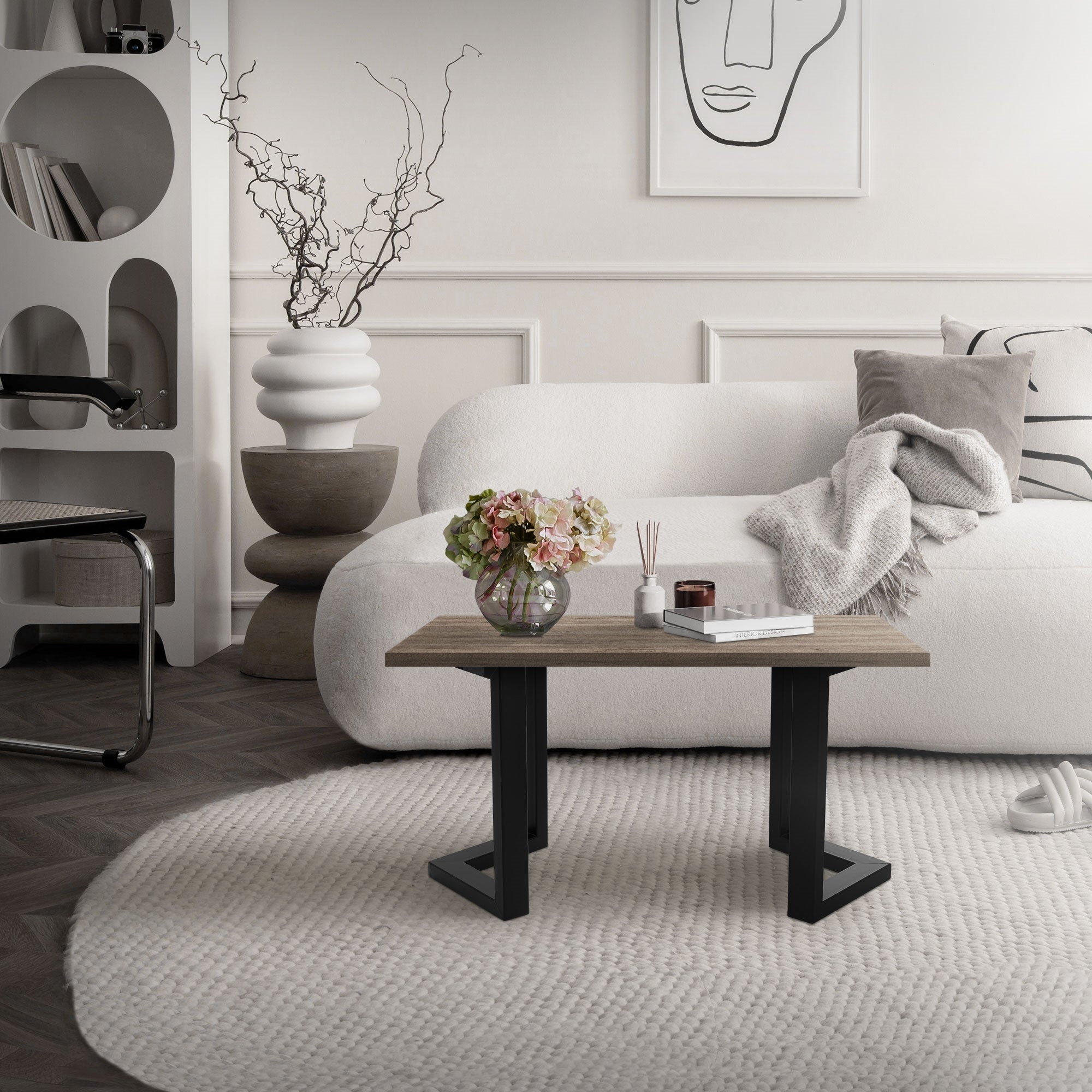Ein moderner Wohnraum mit einem weißen Sofa, einem Holztisch und einer Vase mit Blumen.