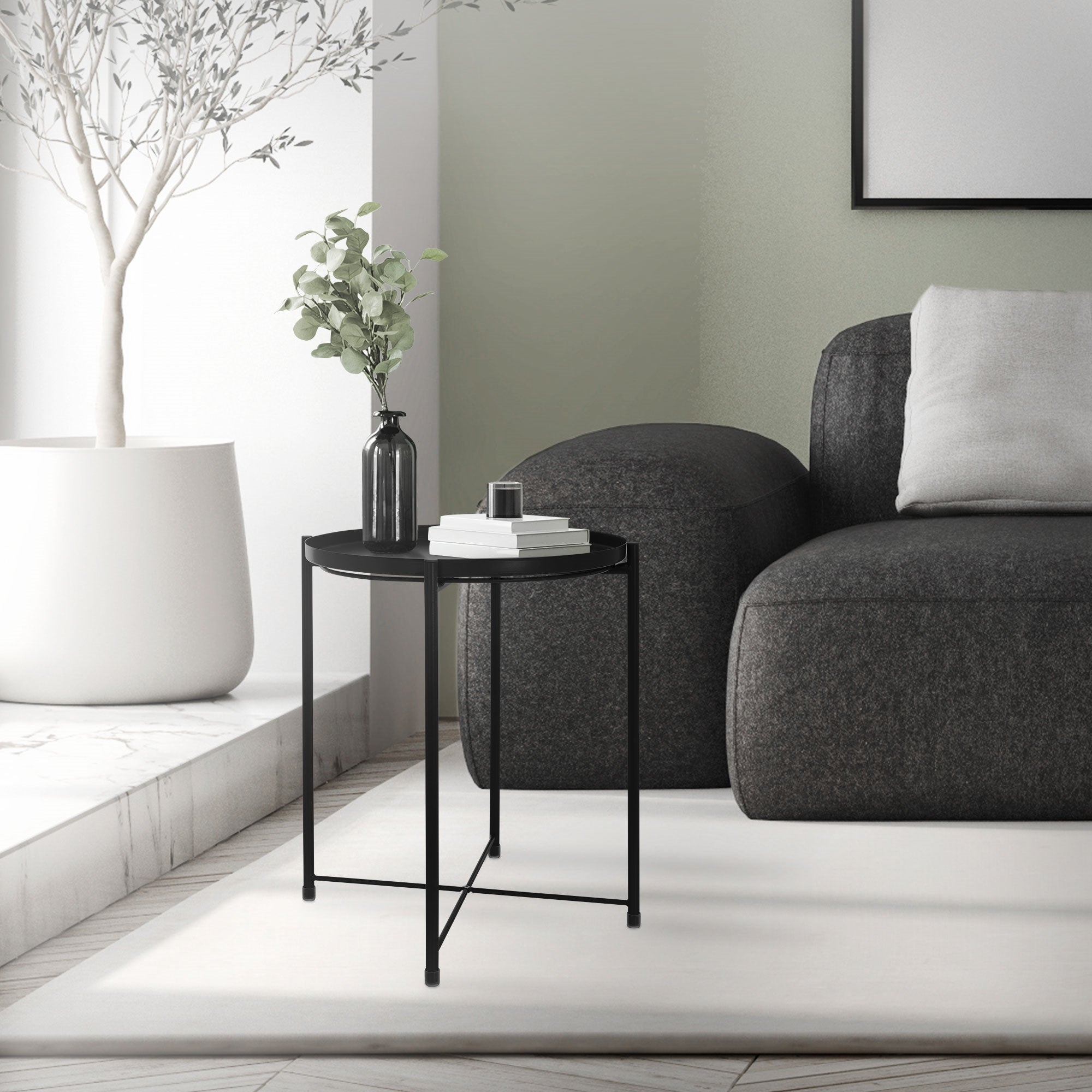 Schwarzer Tisch neben einem Sofa in einem hellen Raum.